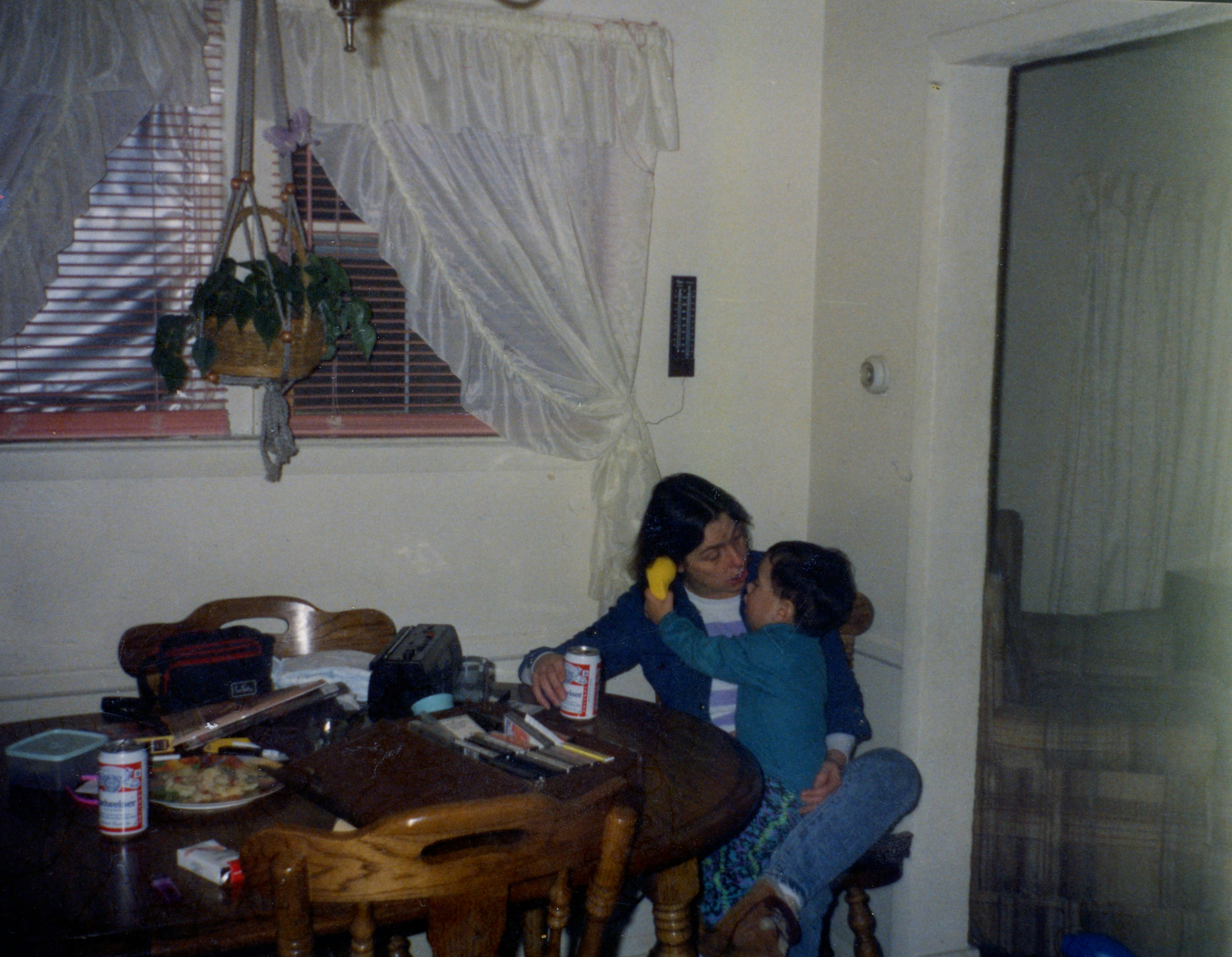 Two parents sitting at a kitchen table on a Sunday evening with a calendar and mugs of tea