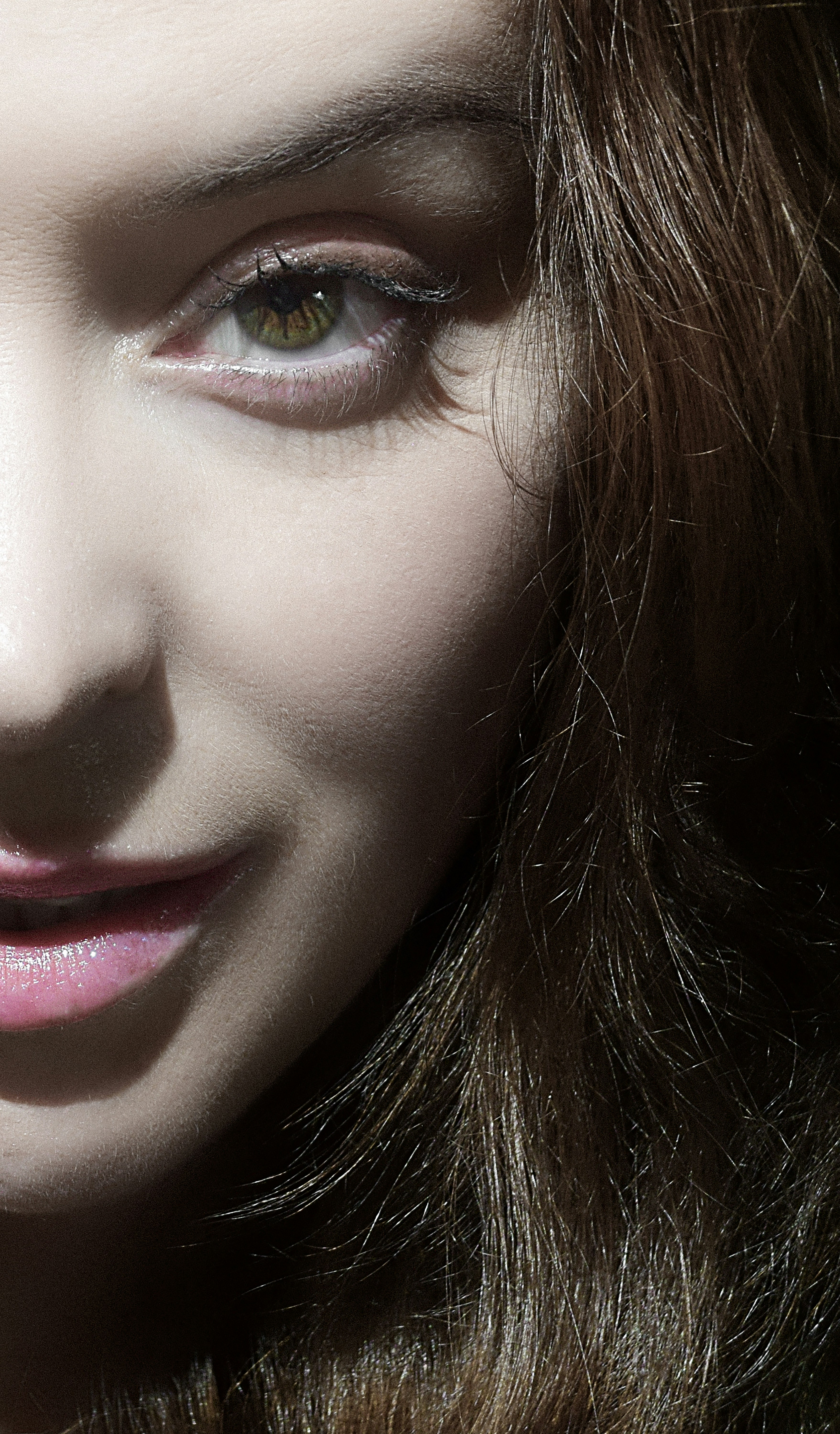 Ojo de mujer y labios con cabello oscuro en sombra.