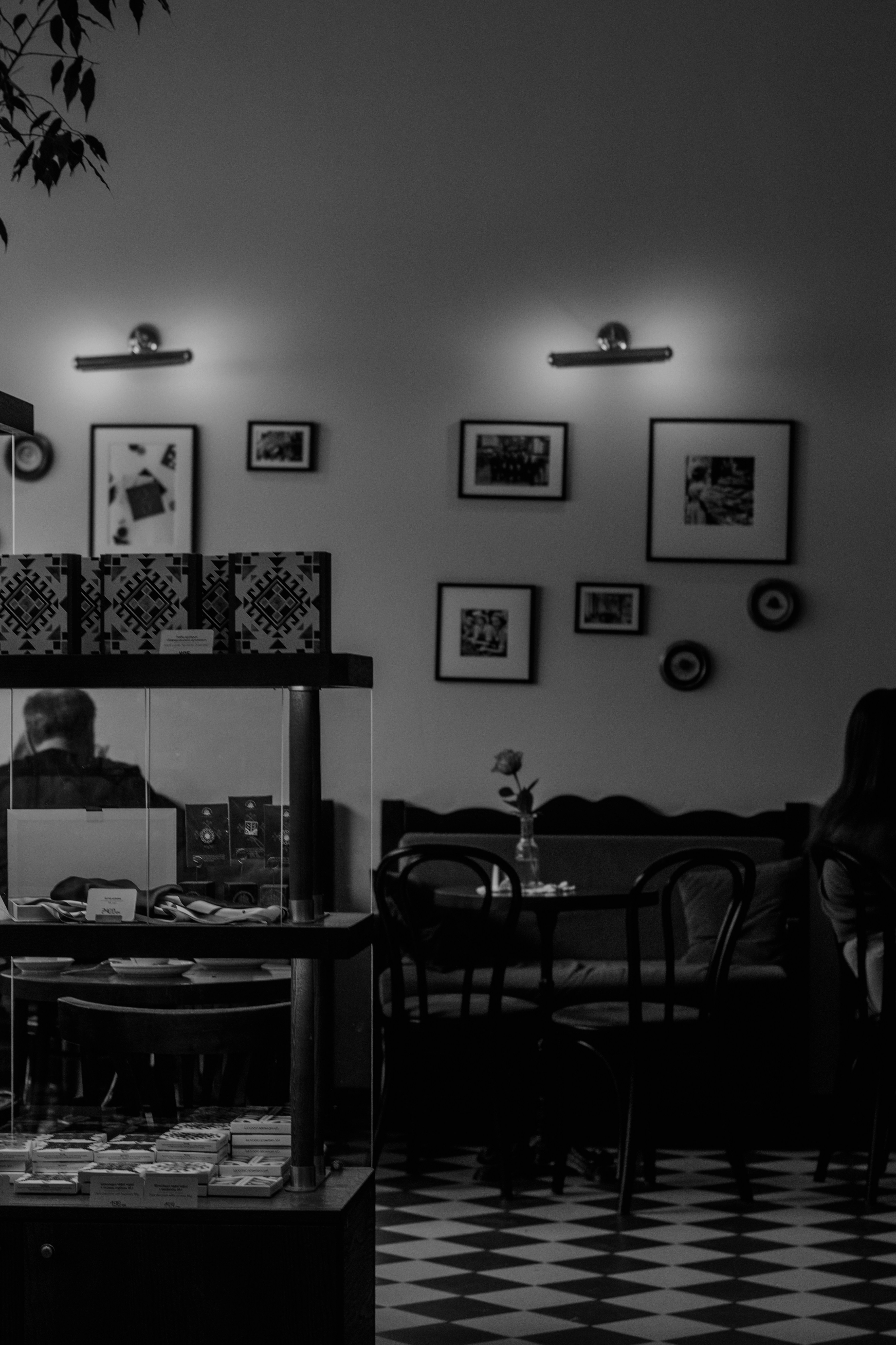 Intérieur de café chaleureux avec des tableaux encadrés et un sol à carreaux.
