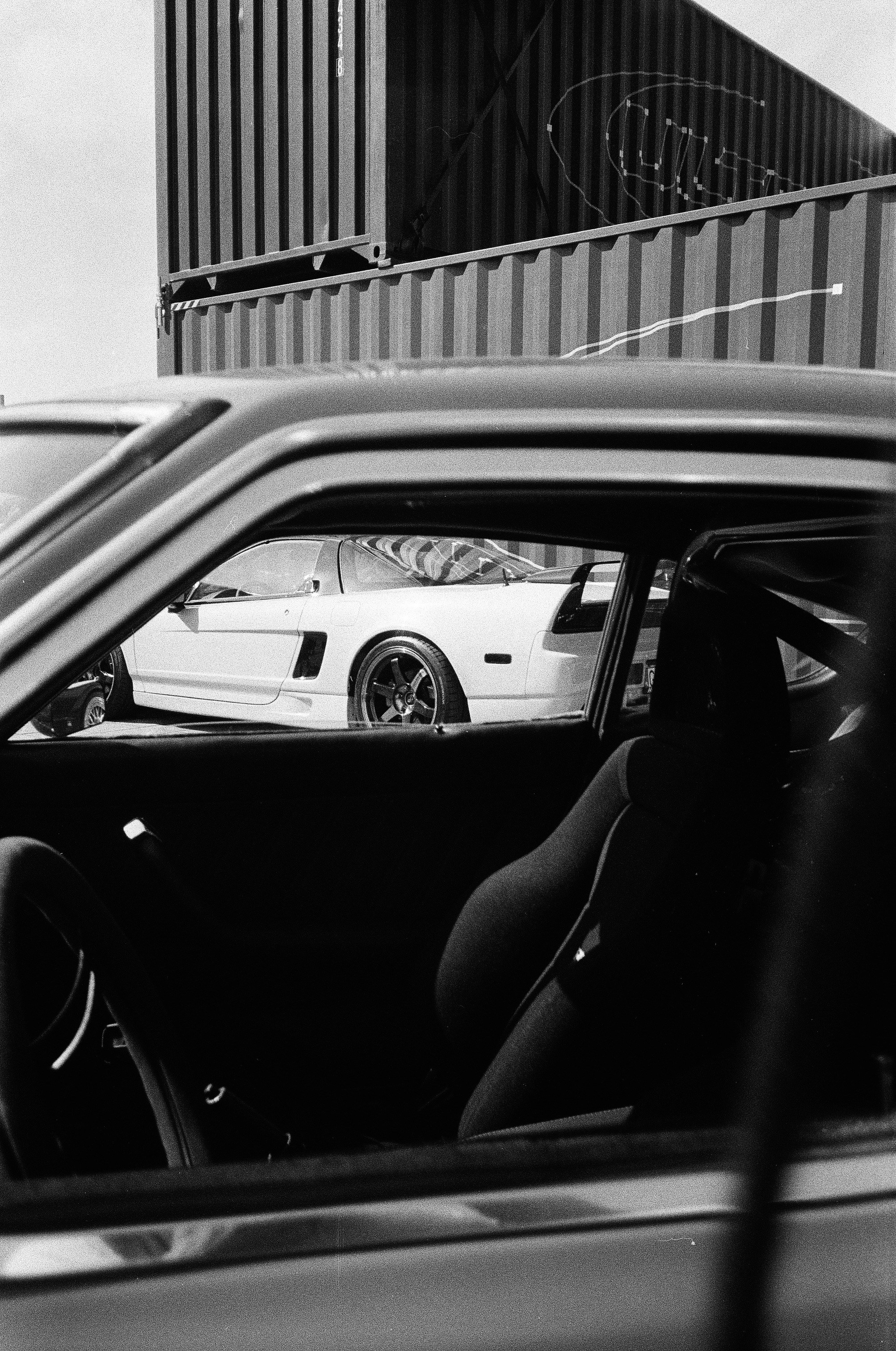 White sports car visible through a car's side window