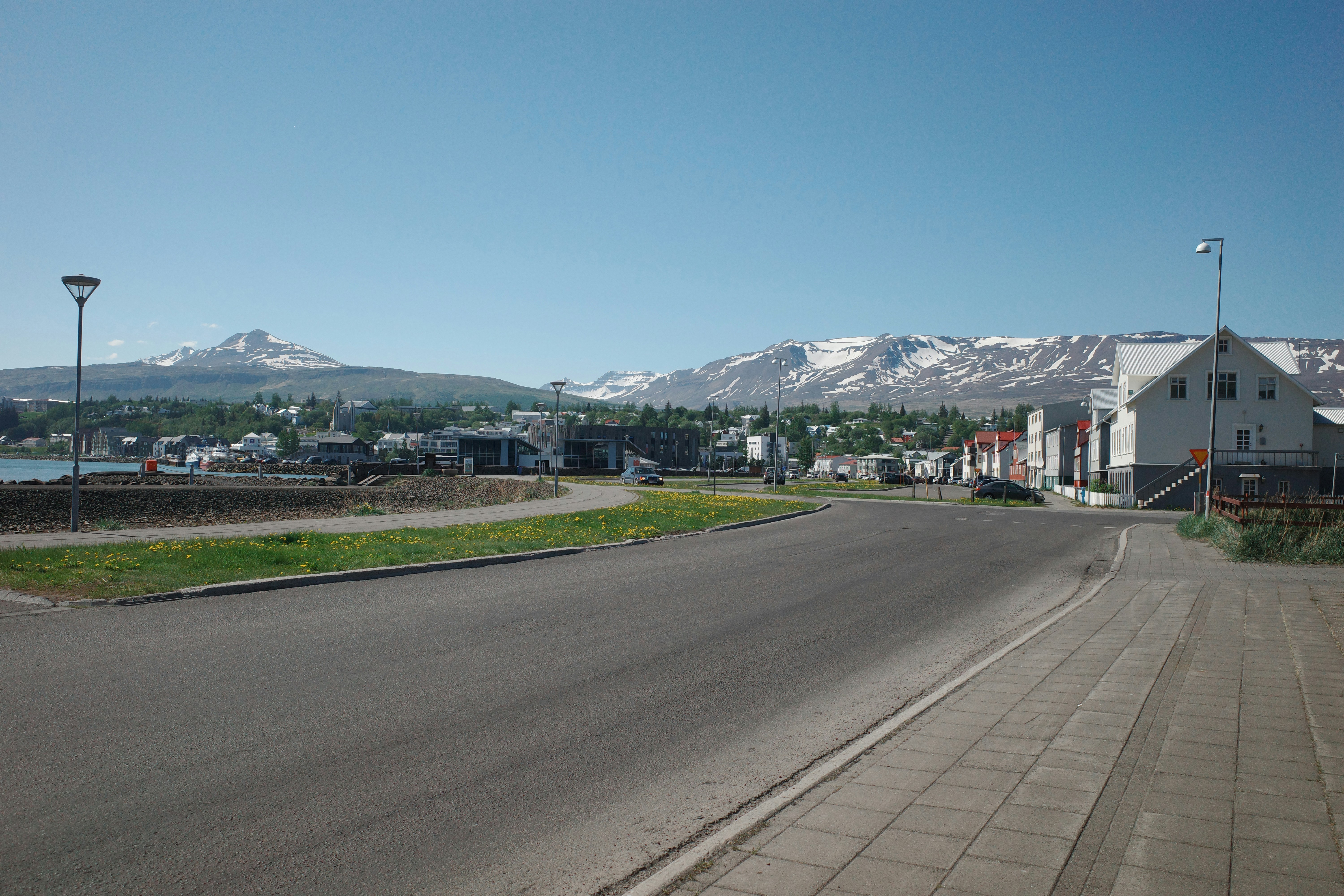 Ville pittoresque avec des montagnes enneigées et un ciel bleu clair.