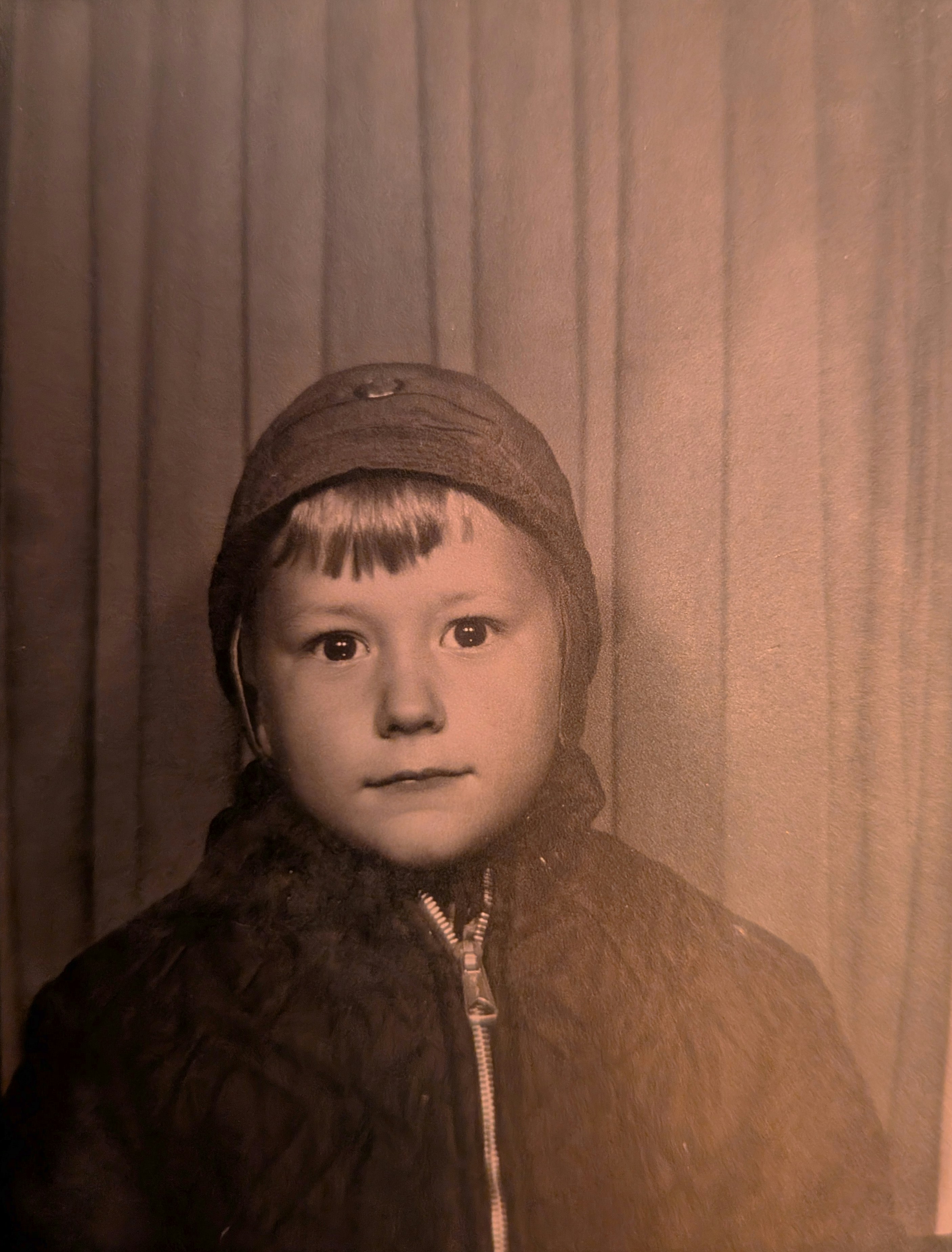 Sepia-toned portrait of a young child in a hat.
