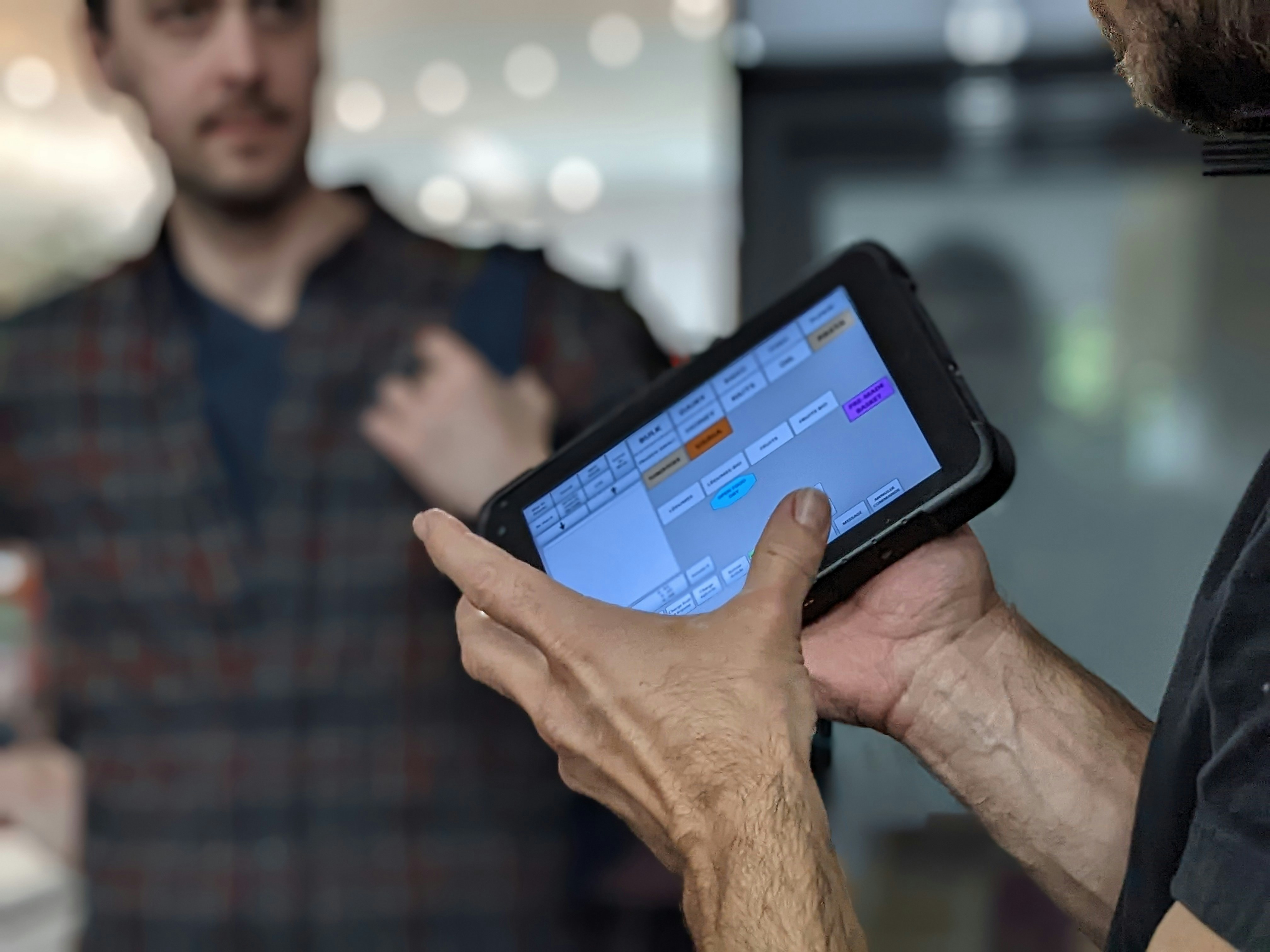 Hands interacting with a tablet displaying a timeline interface.