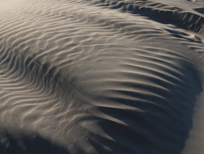 Abstract view of wind-swept sand dunes with rippled patterns.