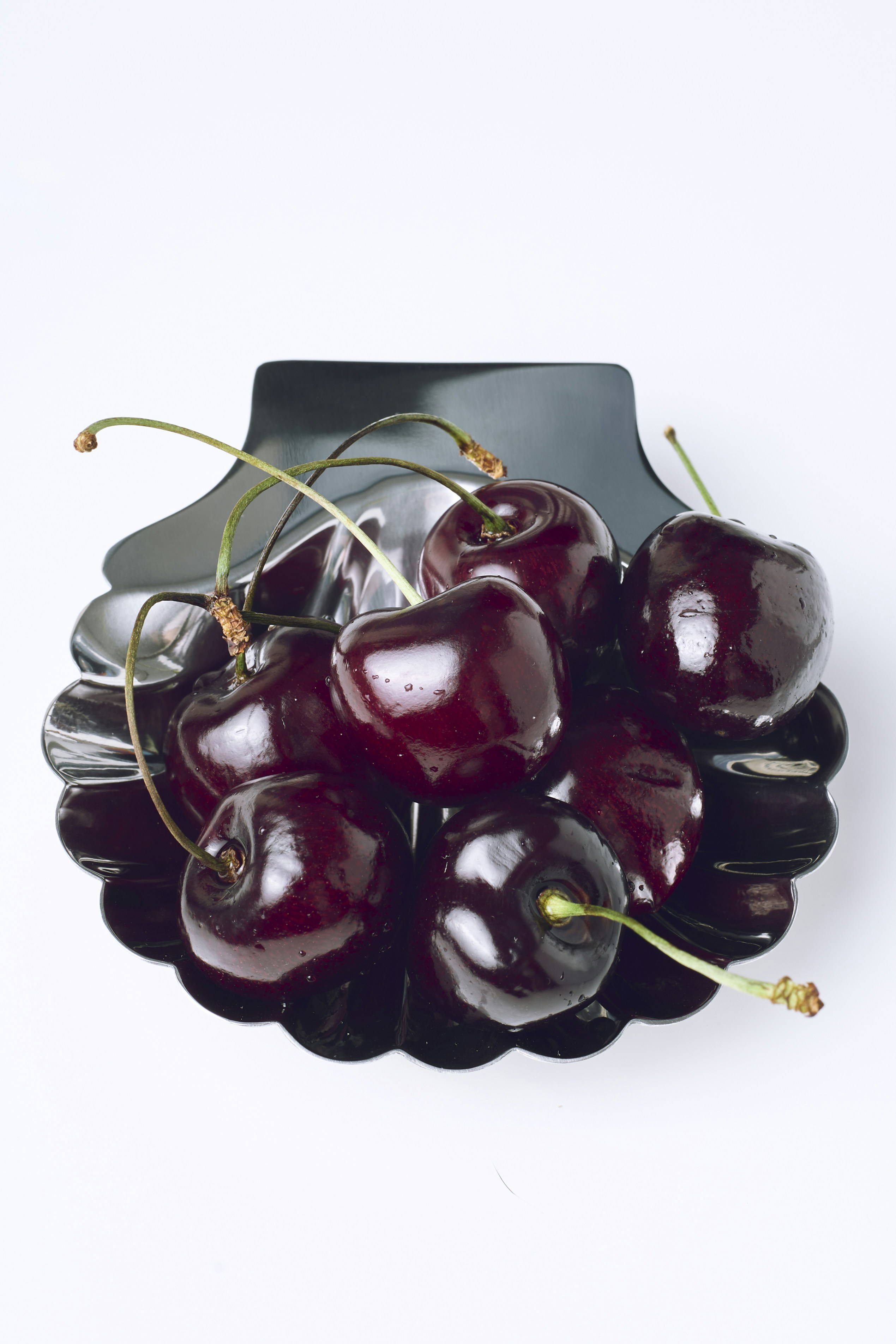Fresh dark cherries in a decorative black bowl