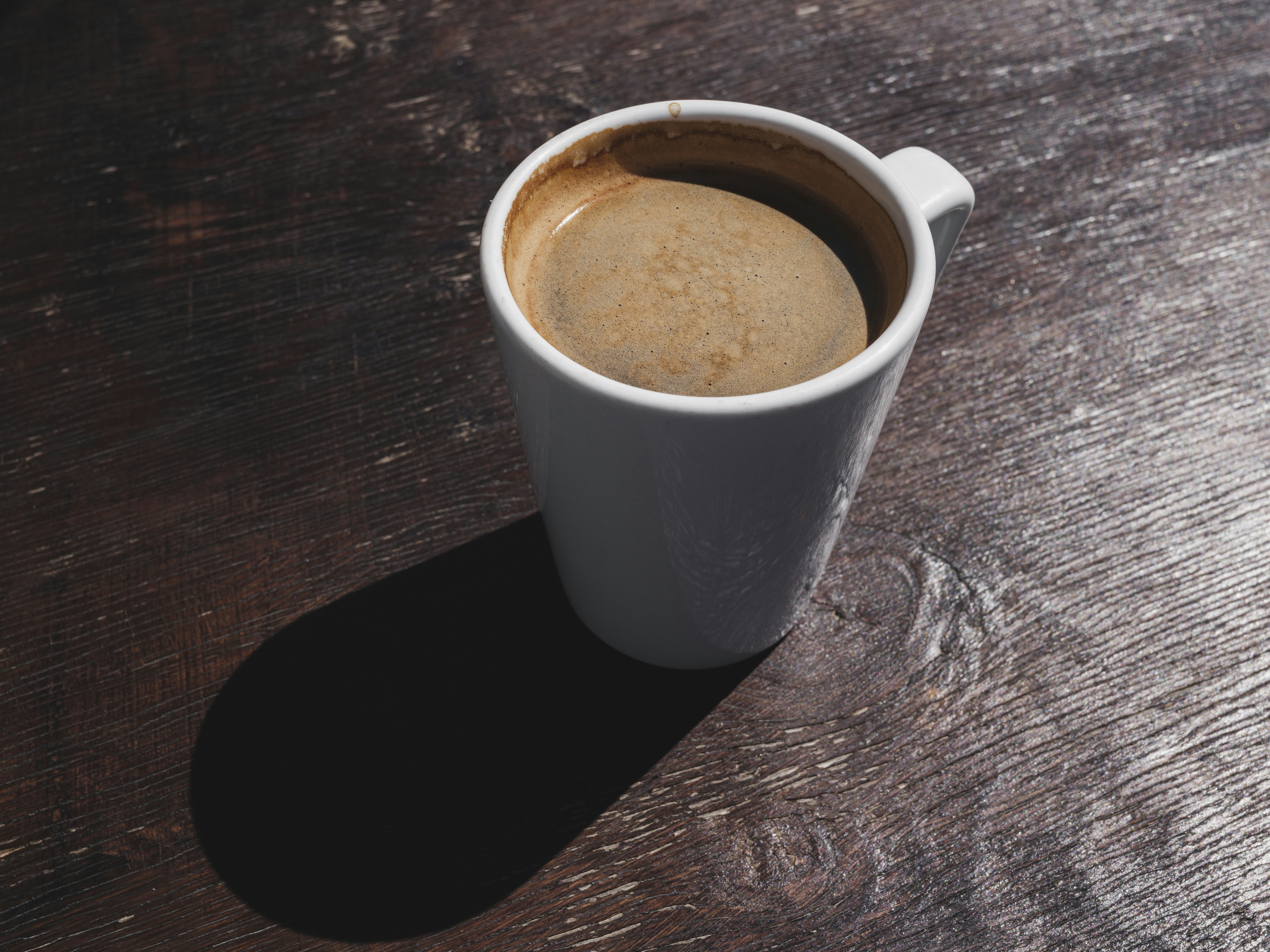 Americano coffee in white mug on wooden table