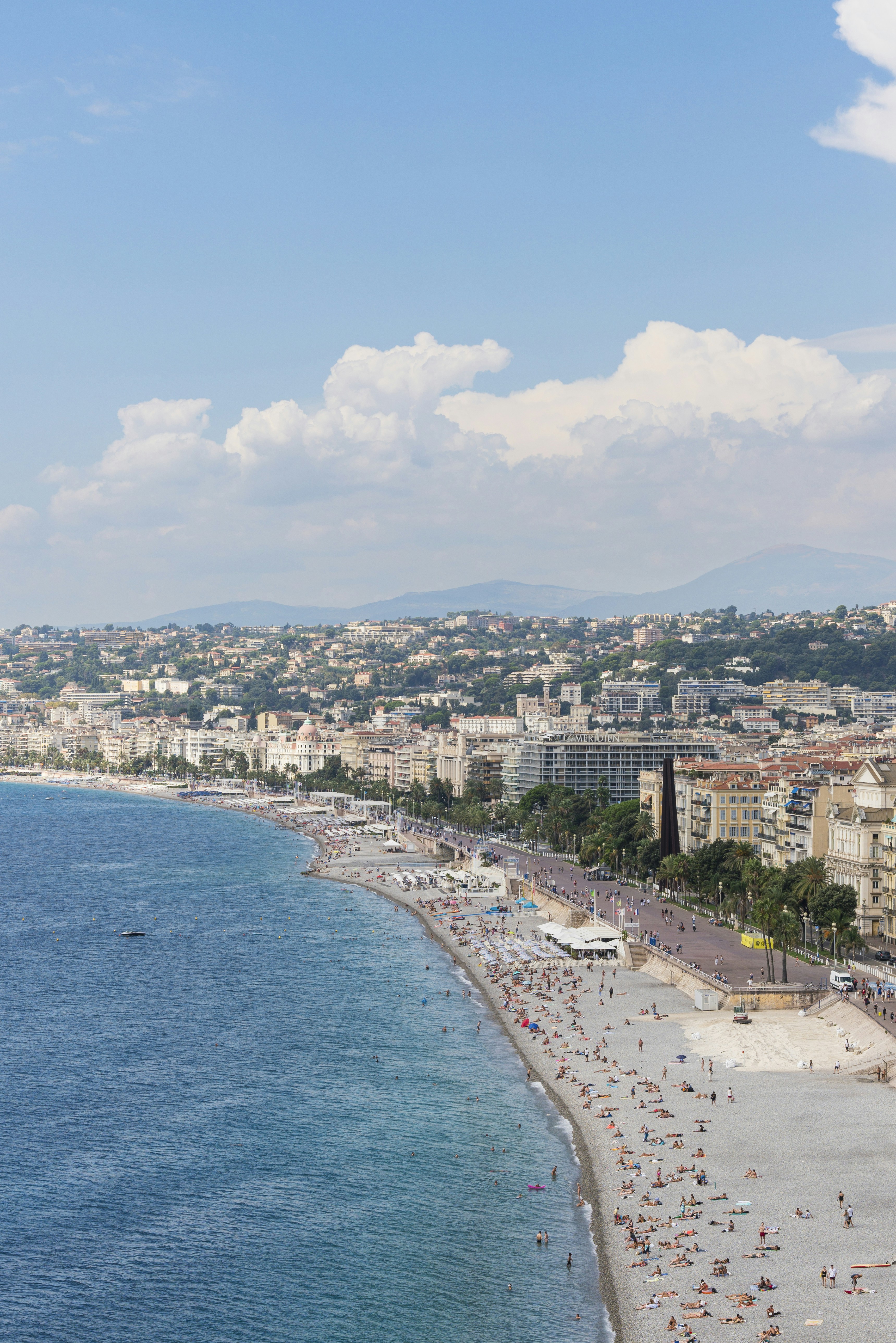 Aerial view of a crowded beach and coastal city.