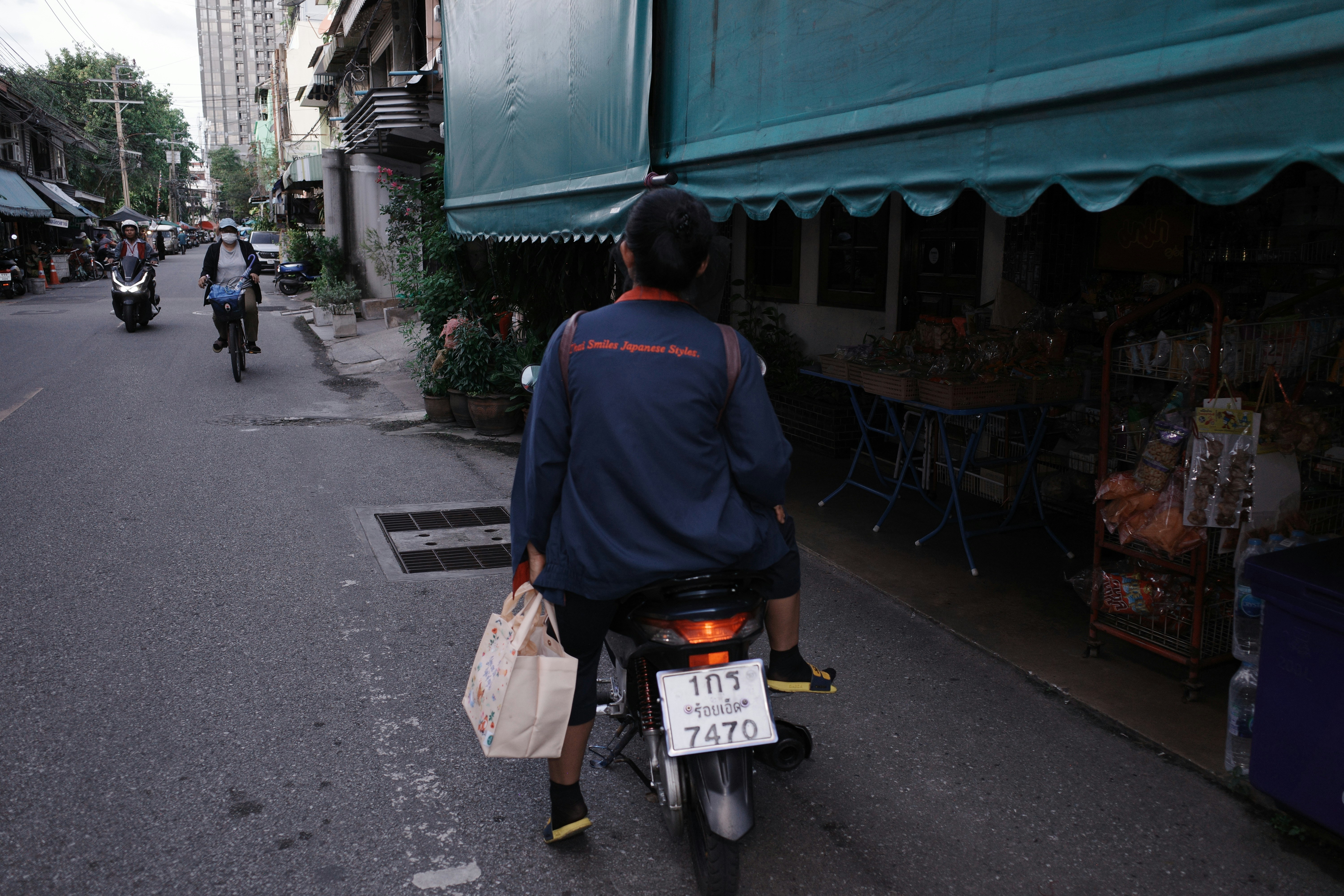 Pessoa andando de scooter com bolsa na rua da cidade