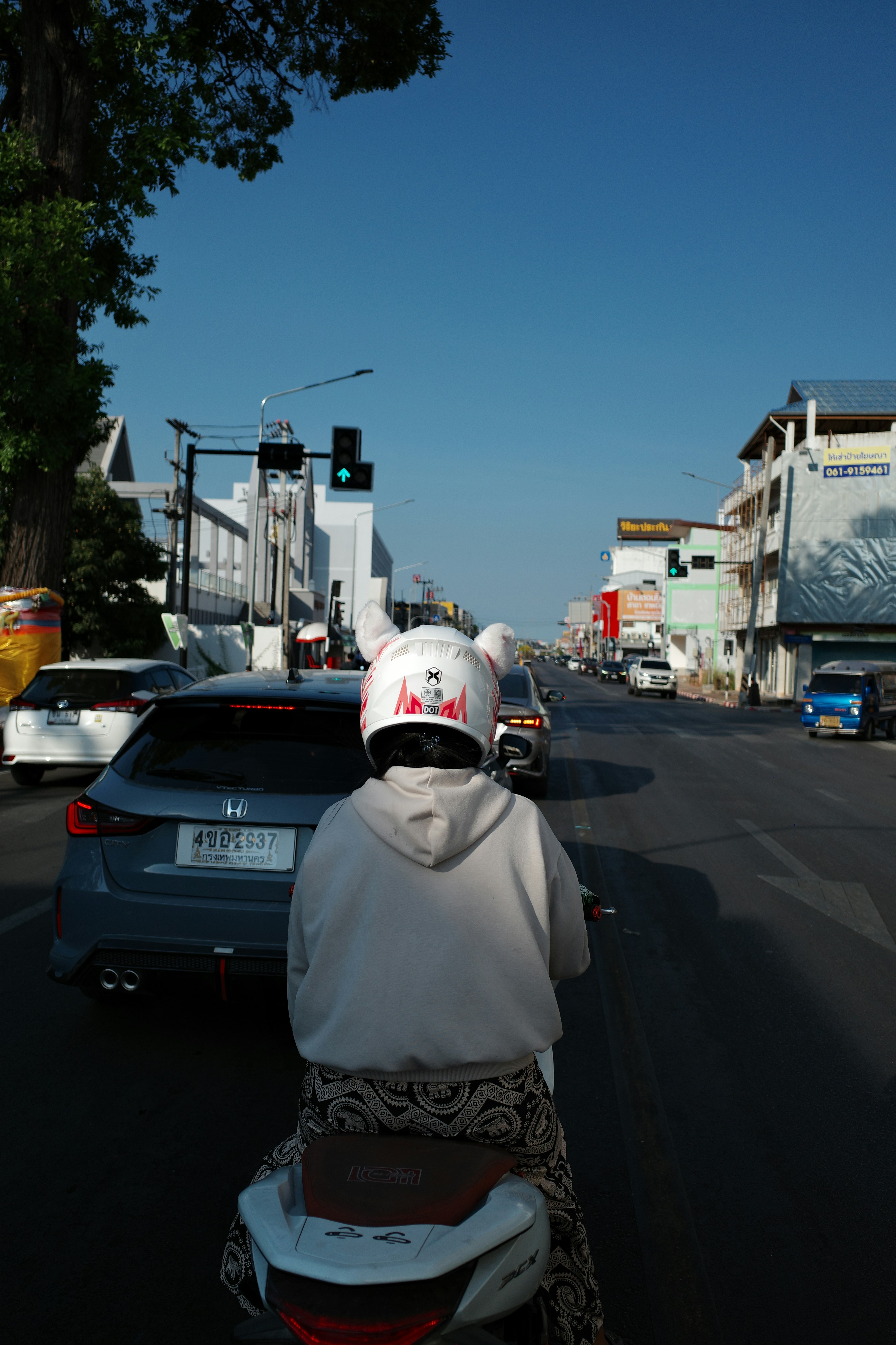 Motorista de scooter com capacete de coelho esperando no trânsito