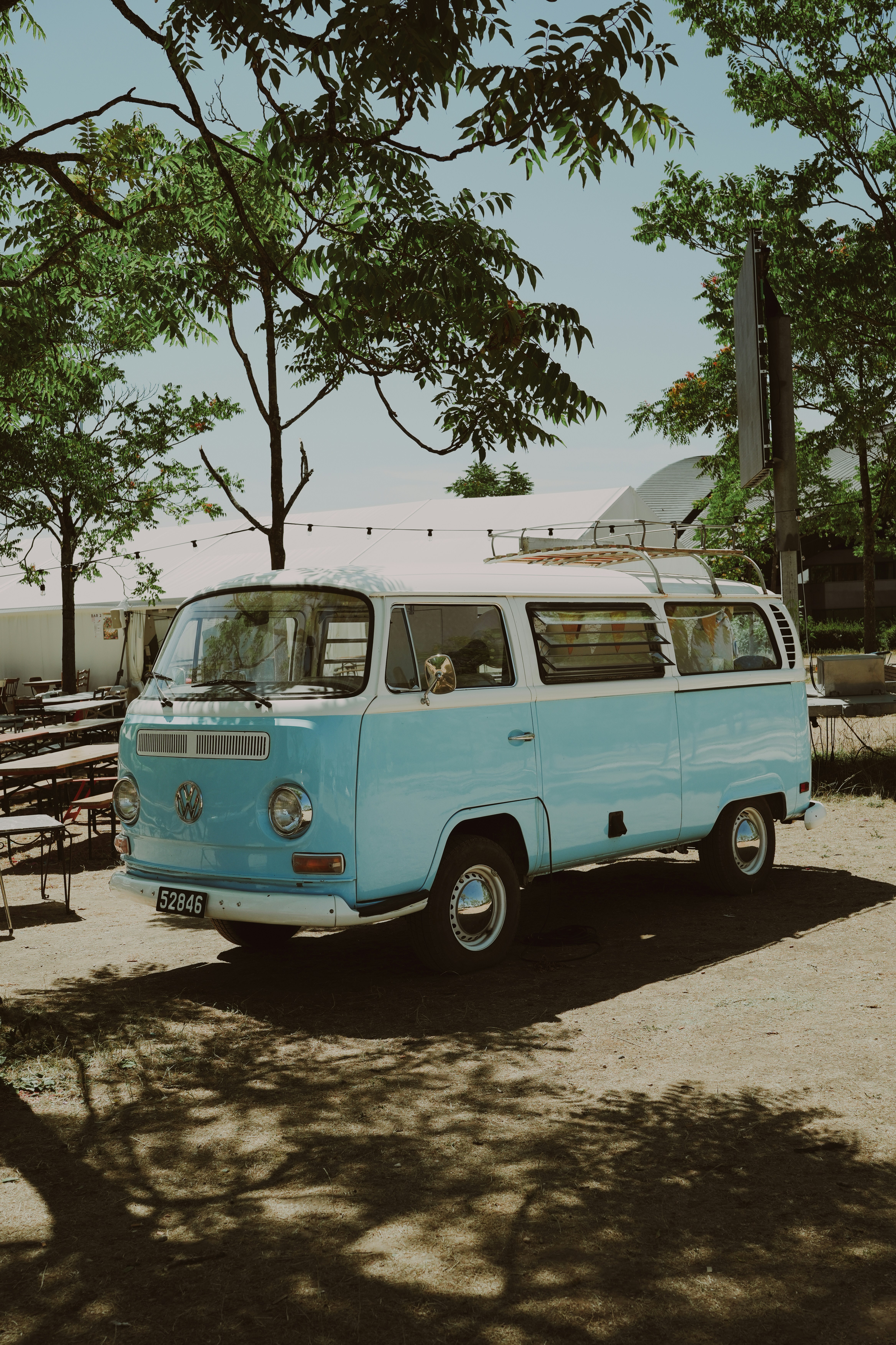 Light blue and white vintage volkswagen van parked outdoors.
