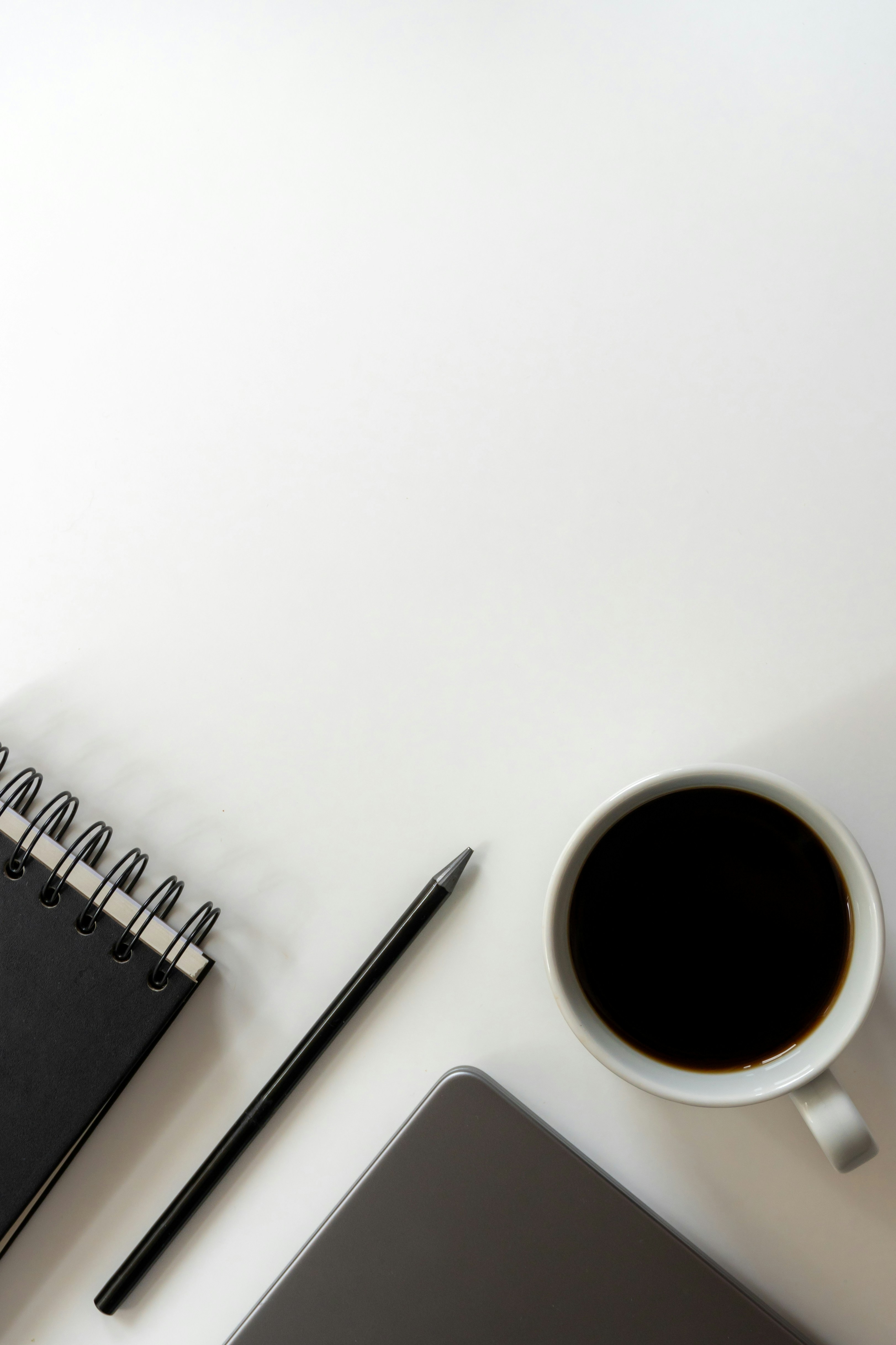 Notebook, café e materiais de trabalho em uma mesa clara