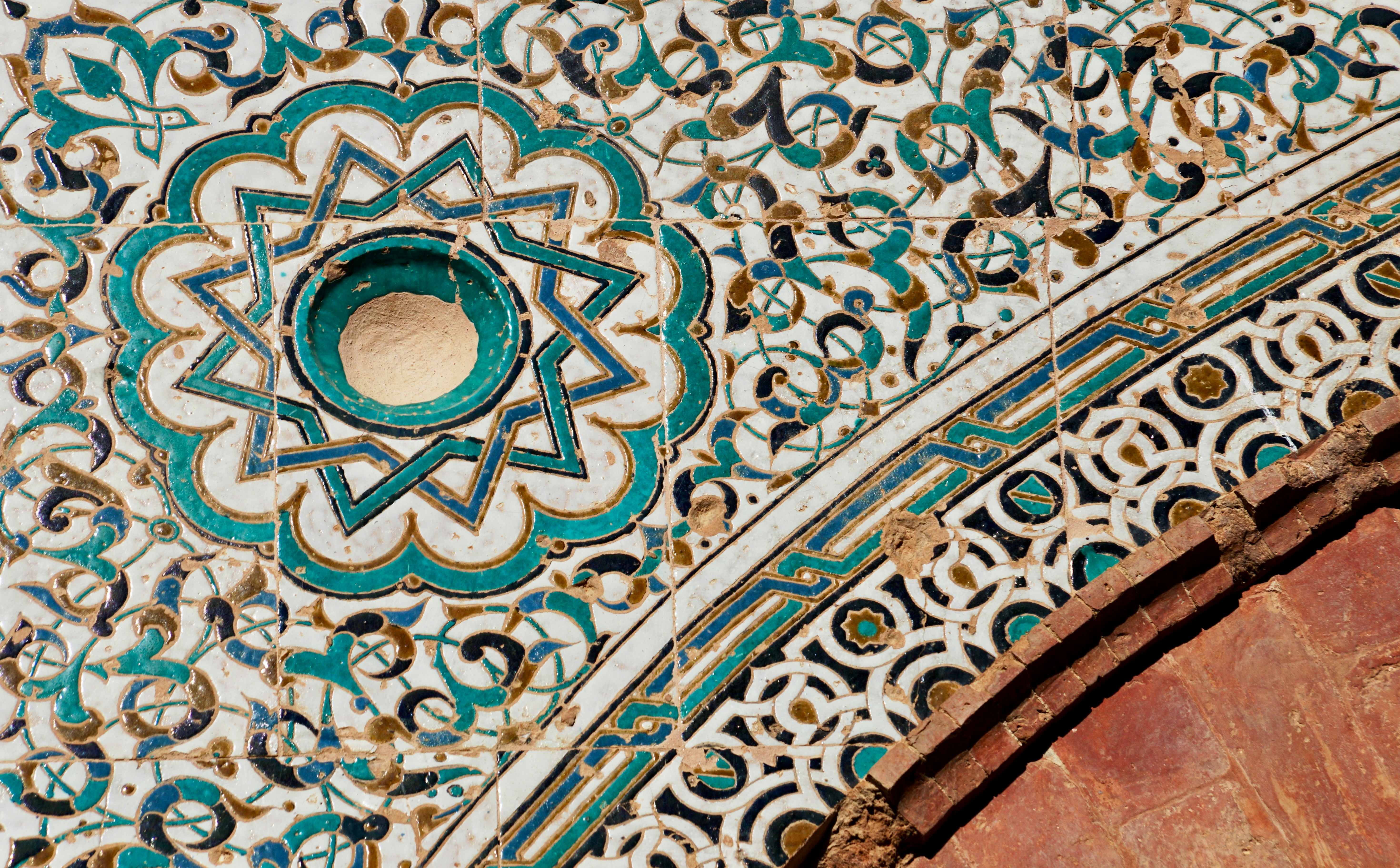 Intricata tegola islamica con motivi geometrici e un arco.