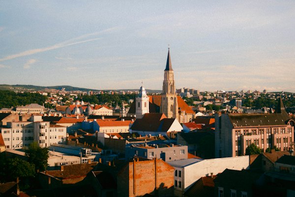 Cluj-Napoca’s red rooftops and the spire of St Michael’s, the hills behind the city