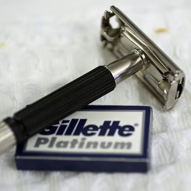 A vintage chrome safety razor beside packets of Gillette Platinum double-edge blades