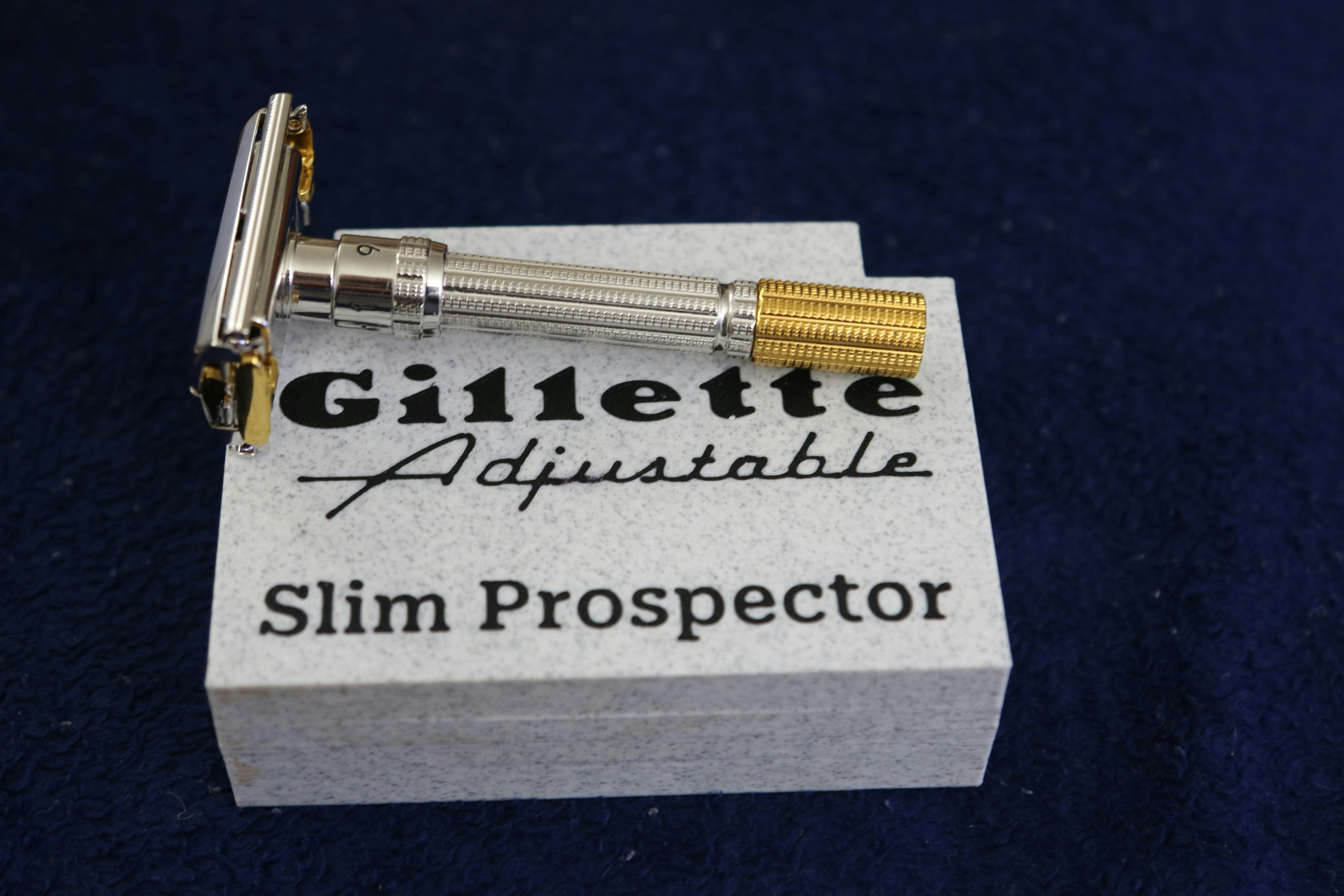 A vintage gillette adjustable slim prospector razor on its box.