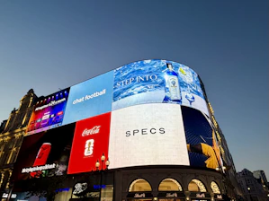 Piccadilly circus building with illuminated digital billboards at dusk