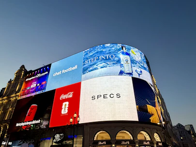 Piccadilly circus building with illuminated digital billboards at dusk