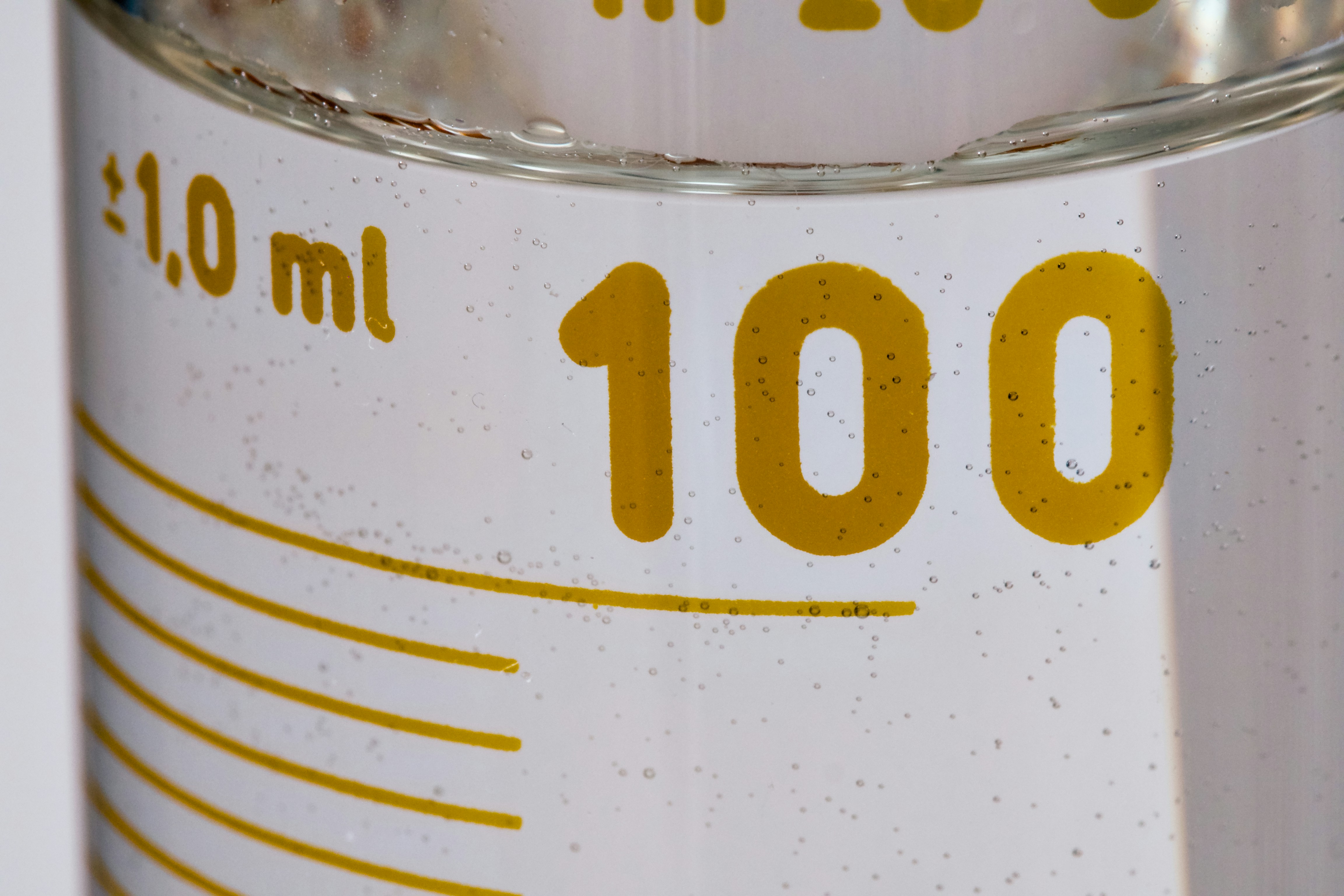 Clear liquid in a measuring cylinder with "100" marking
