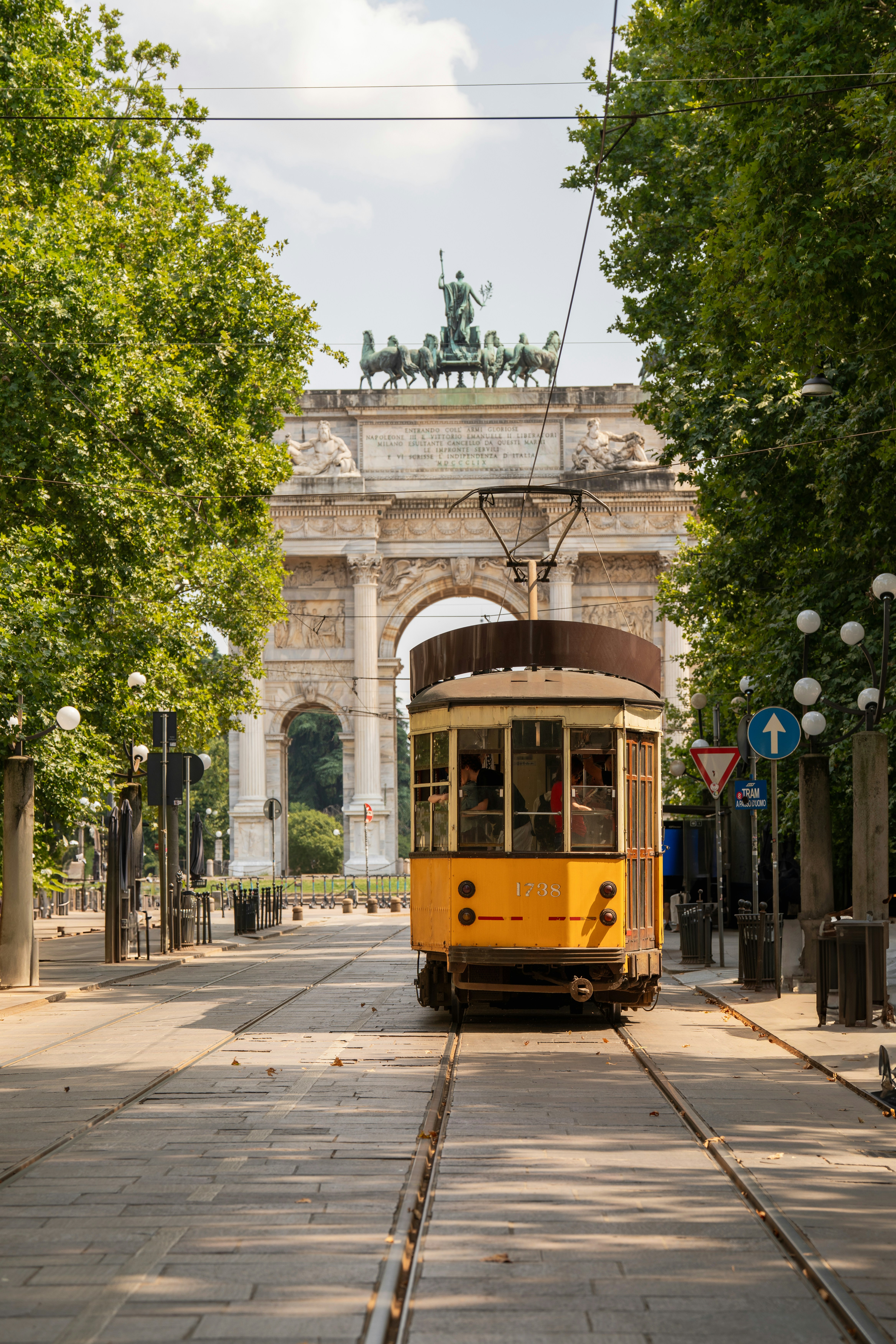 El tranvía amarillo de Milán viaja hacia el arco de la pace.