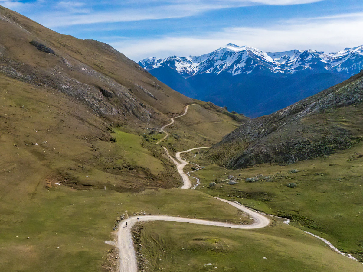Camino de tierra que atraviesa un valle de montaña