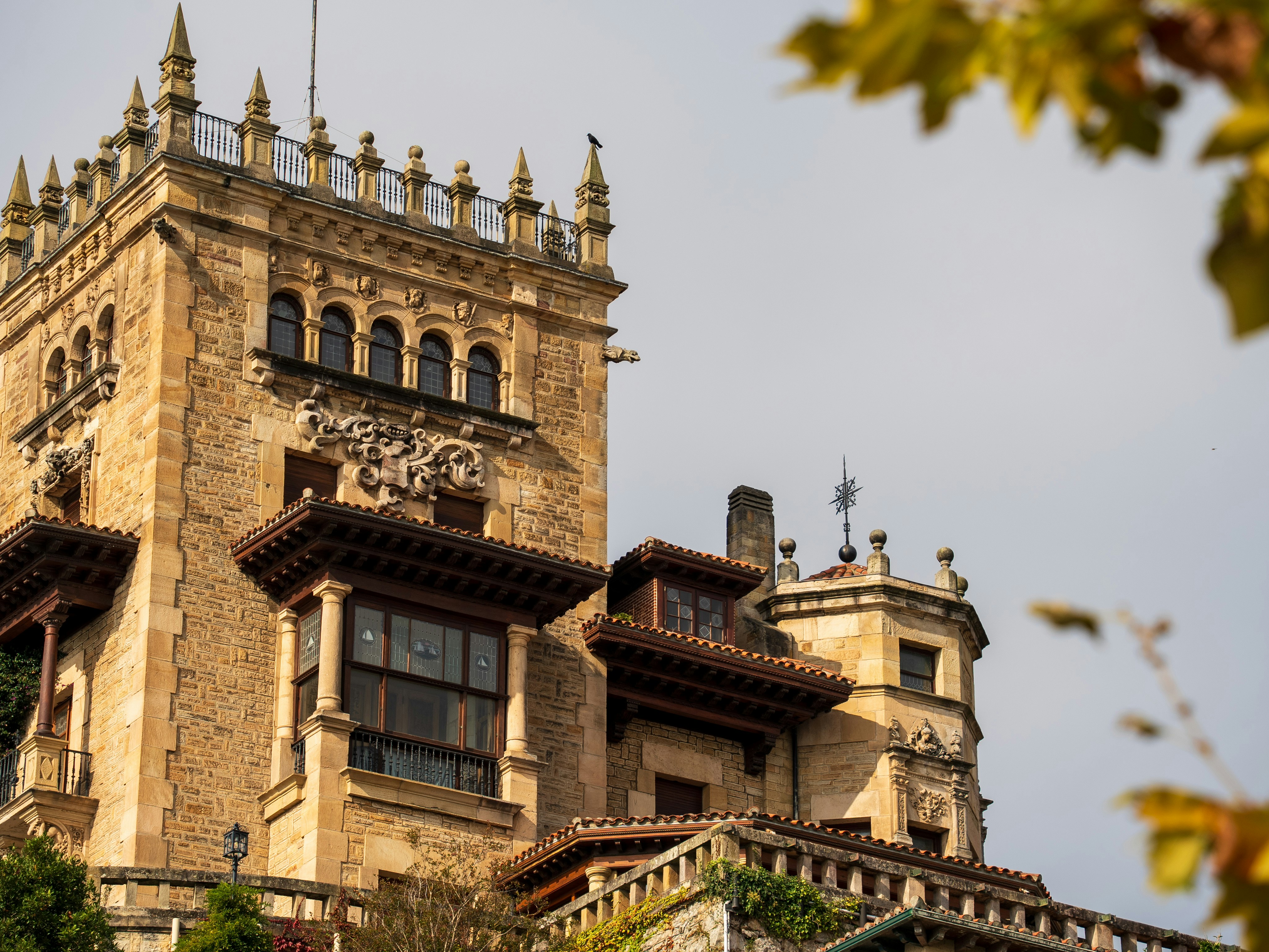 Historic stone castle with intricate details and autumn leaves