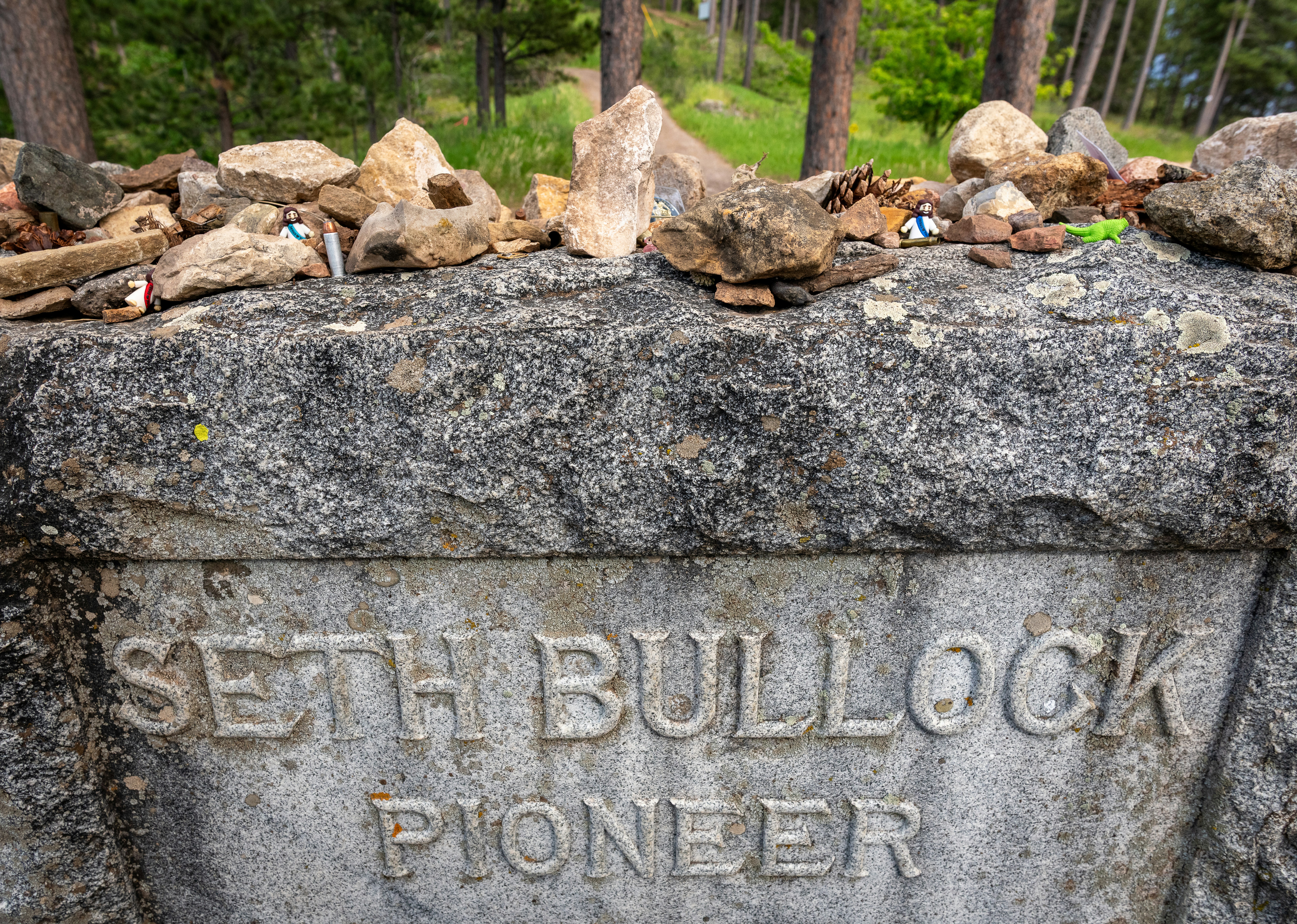 Monumento in pietra per Seth Bullock, pioniere, sormontato da rocce.
