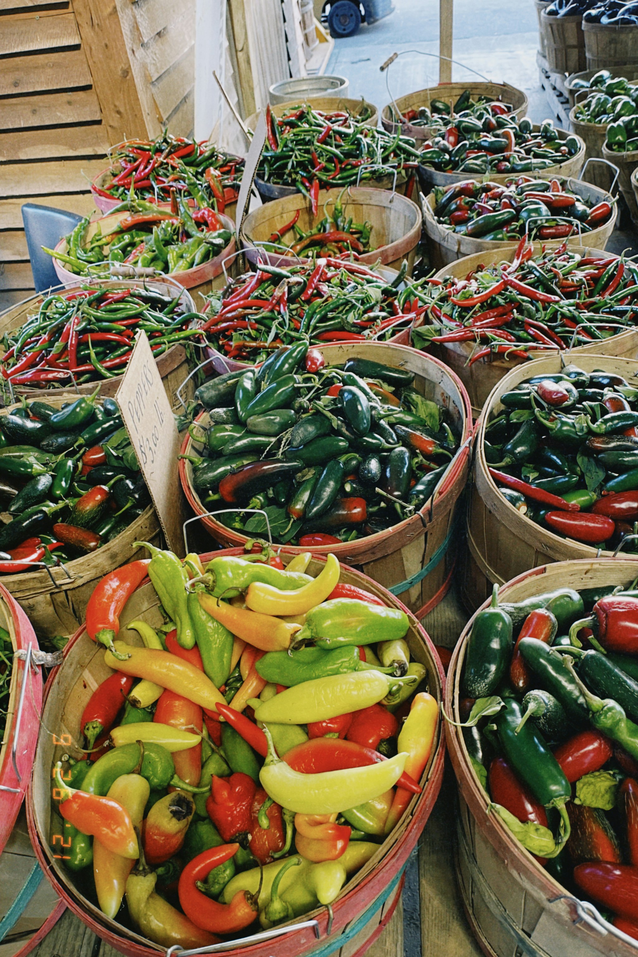 Canastas con chiles jalapeños y otros pimientos en un mercado