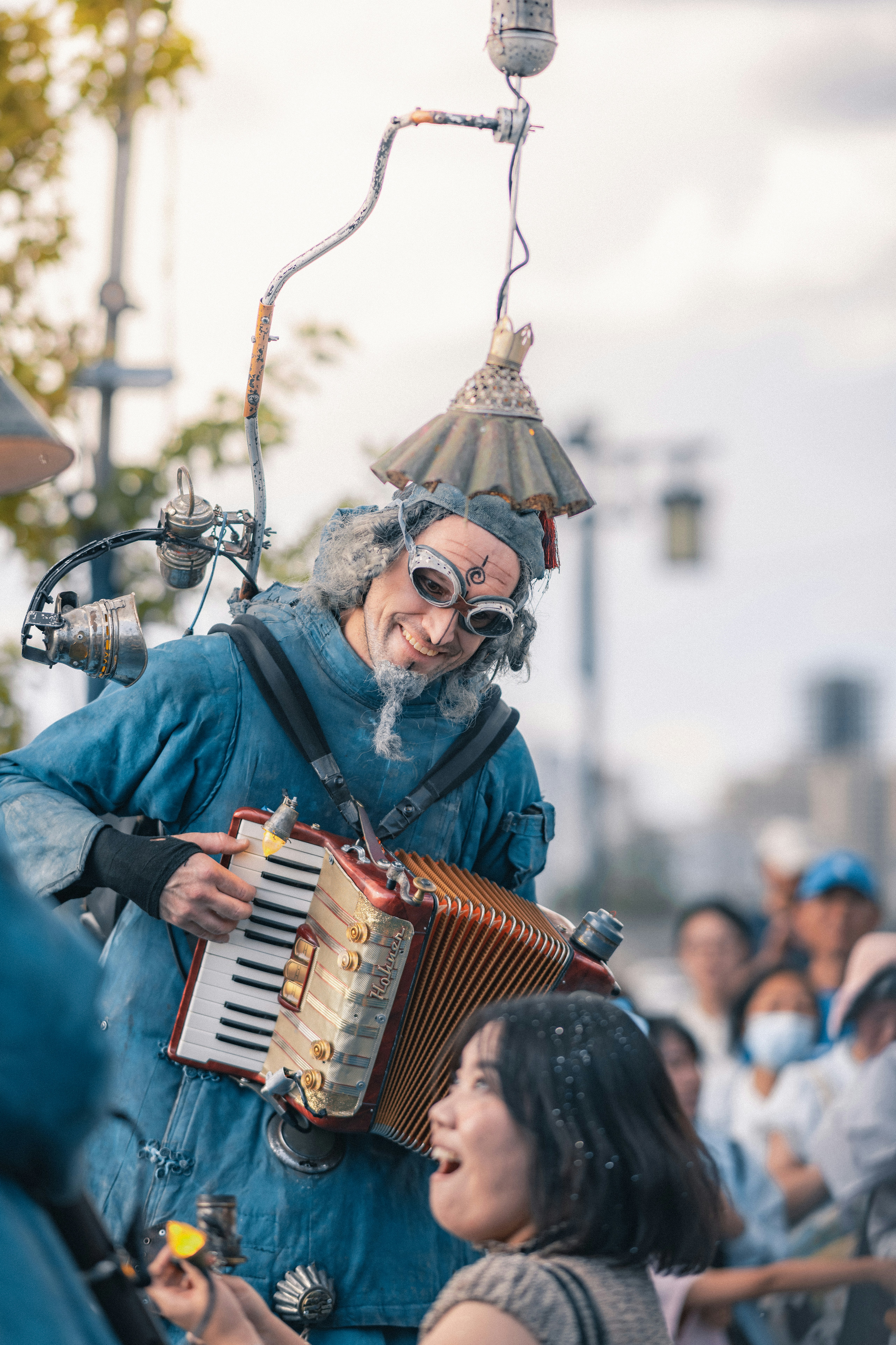 Un artista di strada che suona la fisarmonica per una donna sorridente.