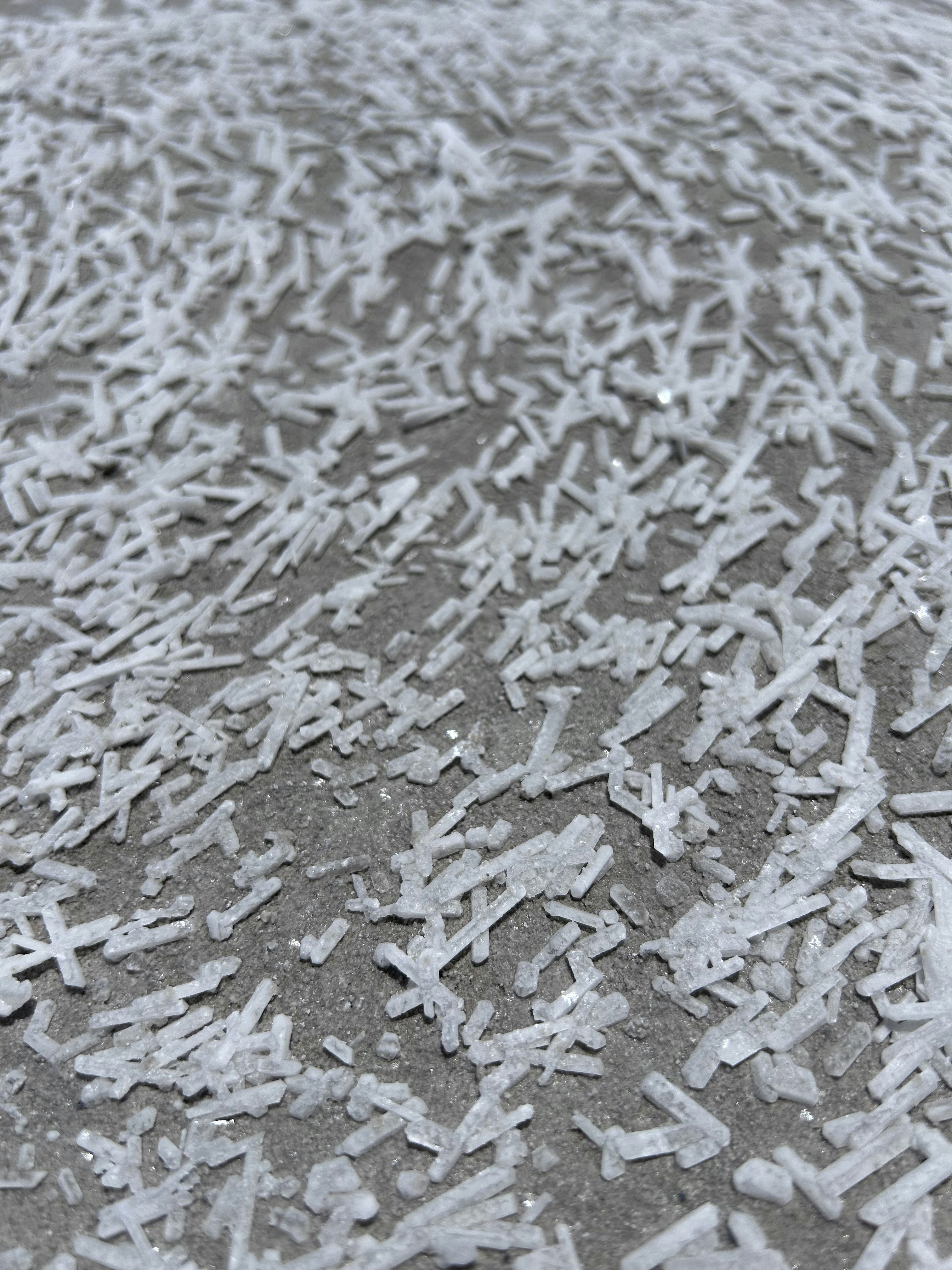 Sharp ice crystals cover a dark, textured surface.