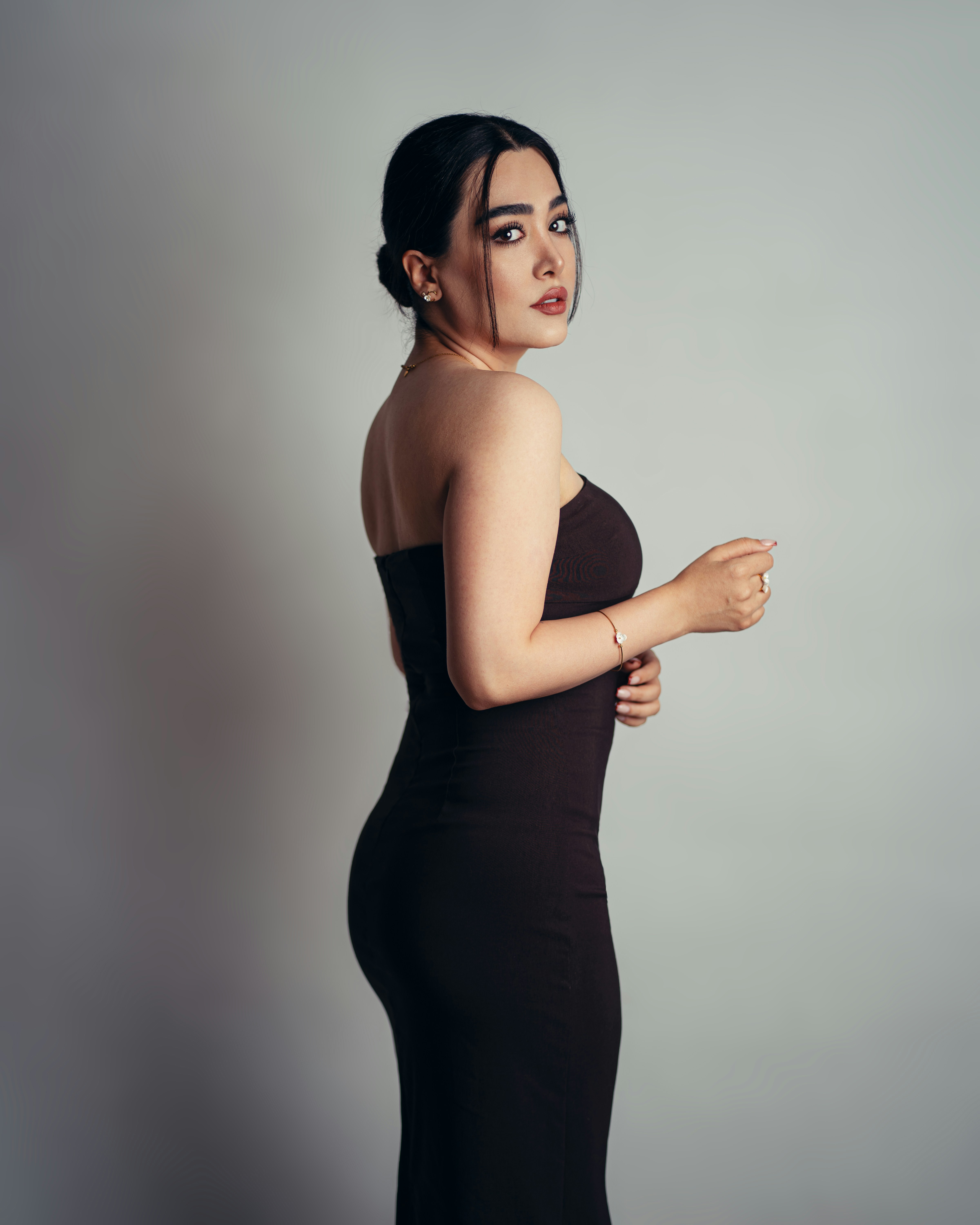 Elegant woman in black dress looking back at the camera
