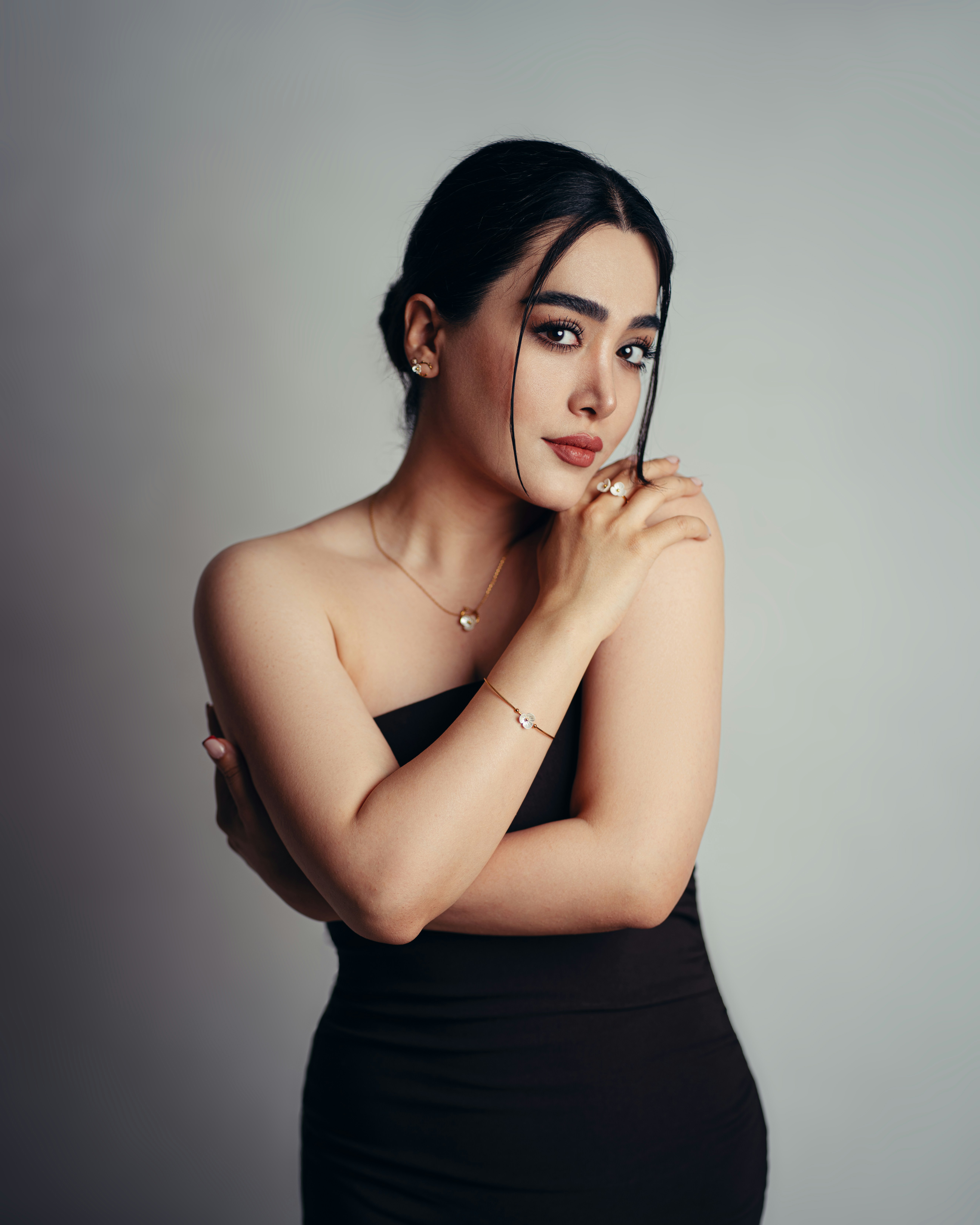 Elegant woman in black dress on a plain background