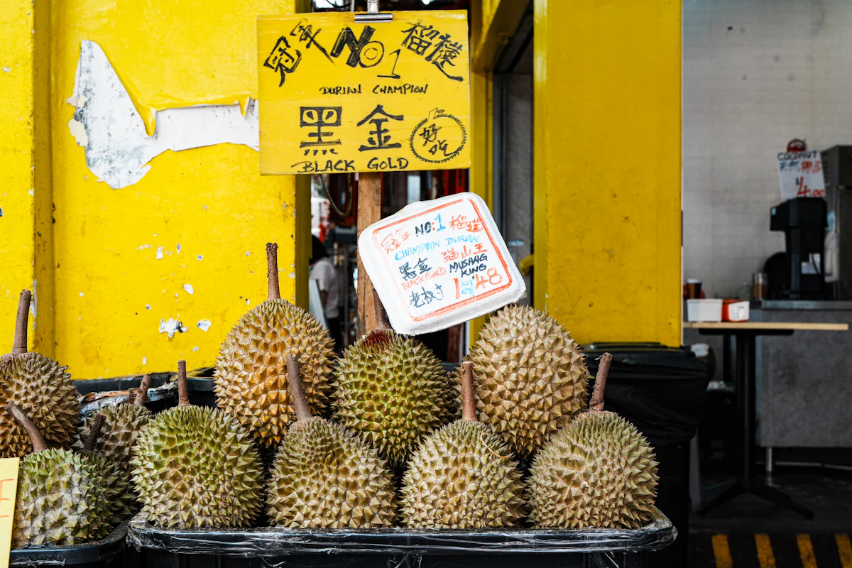 Fresh durians for sale at a bright yellow market stall