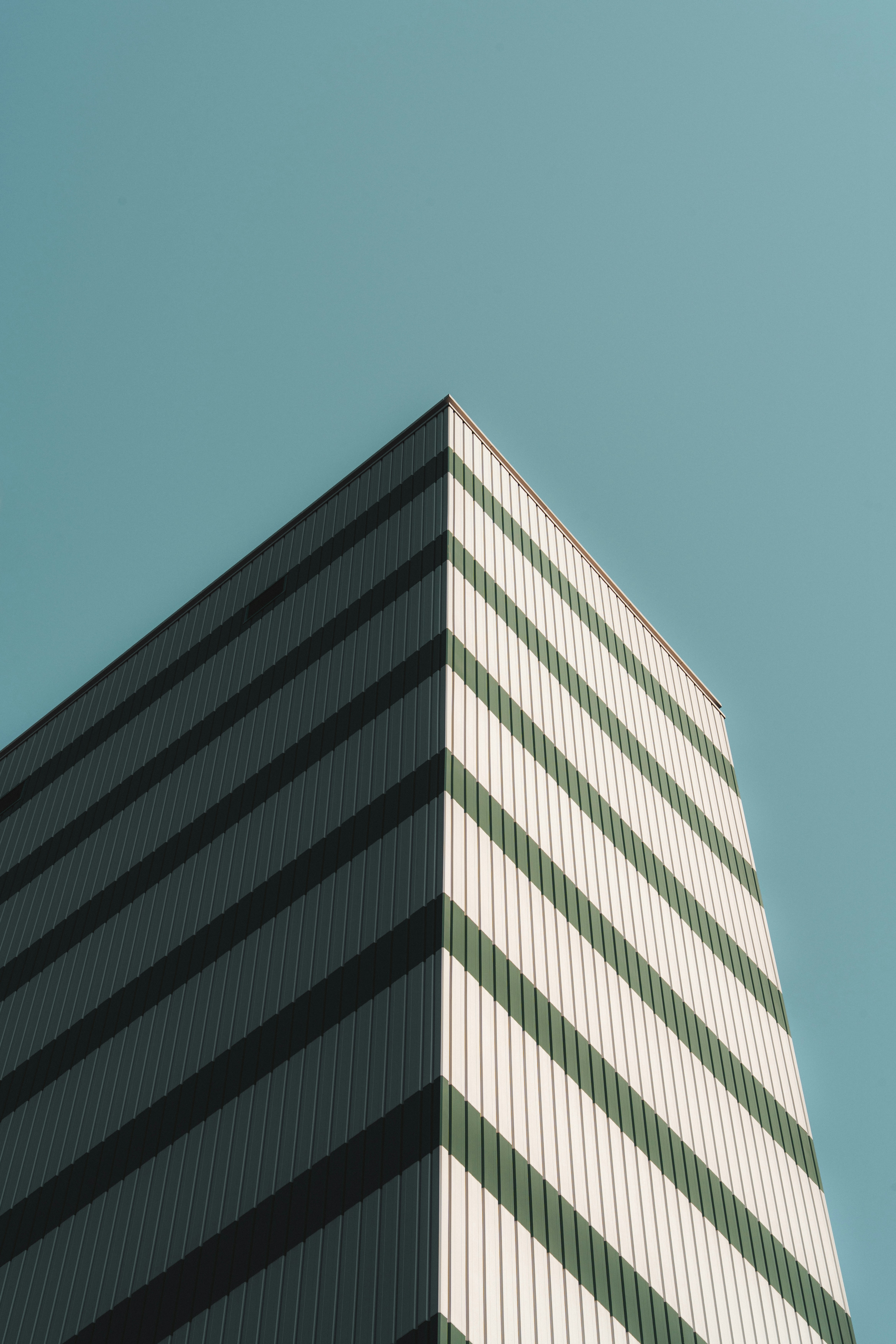 Striped building corner against a clear blue sky.