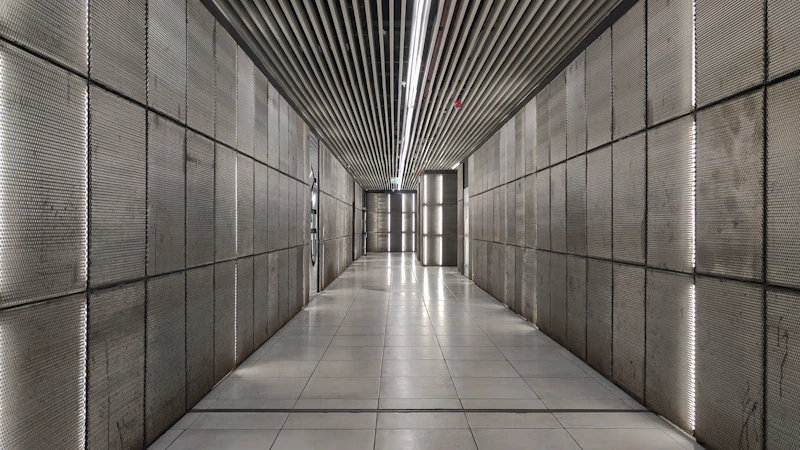 Moderner Betonflur mit linearer Beleuchtung und glänzendem Boden