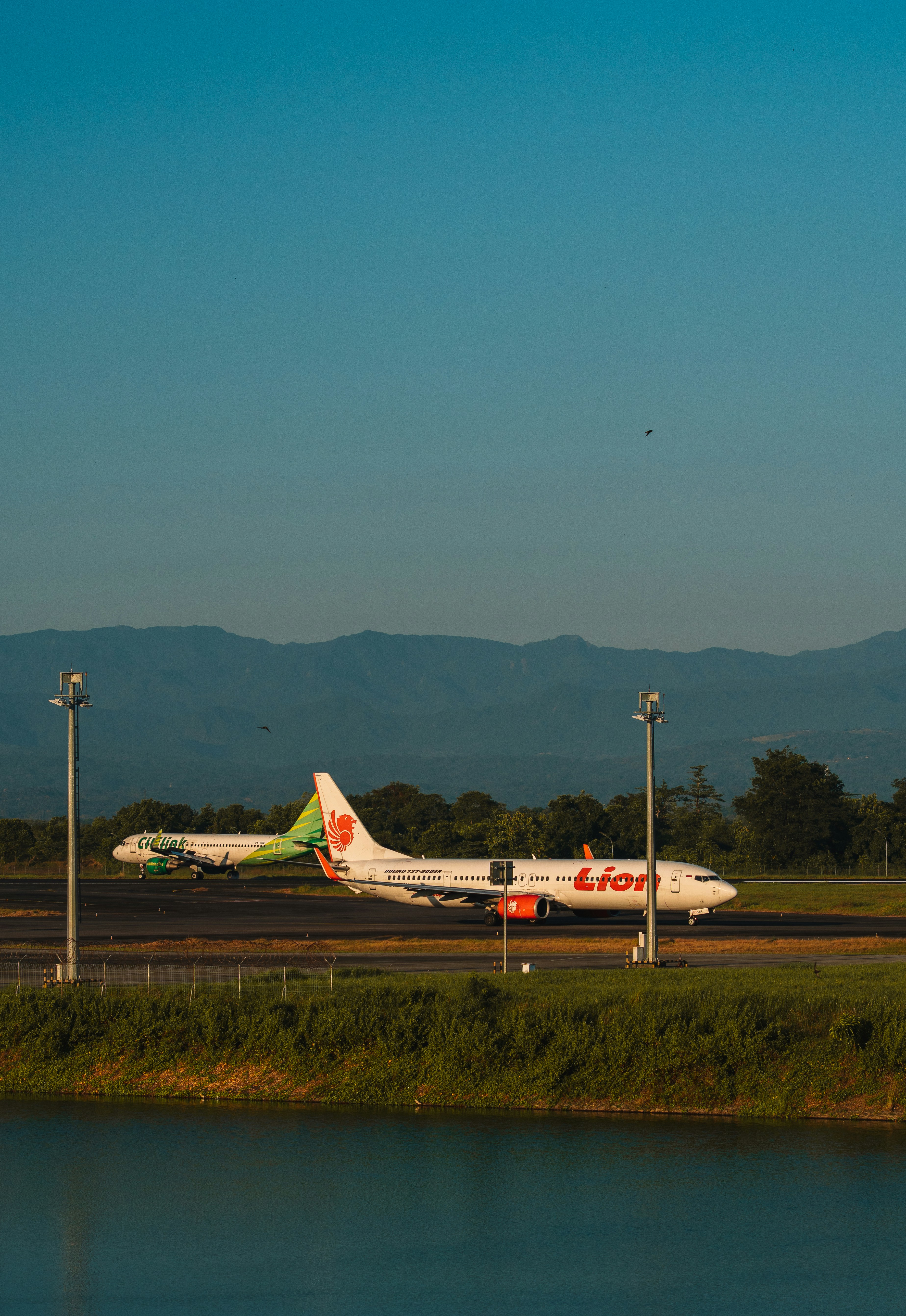 Avião Lion taxiando na pista com montanhas.