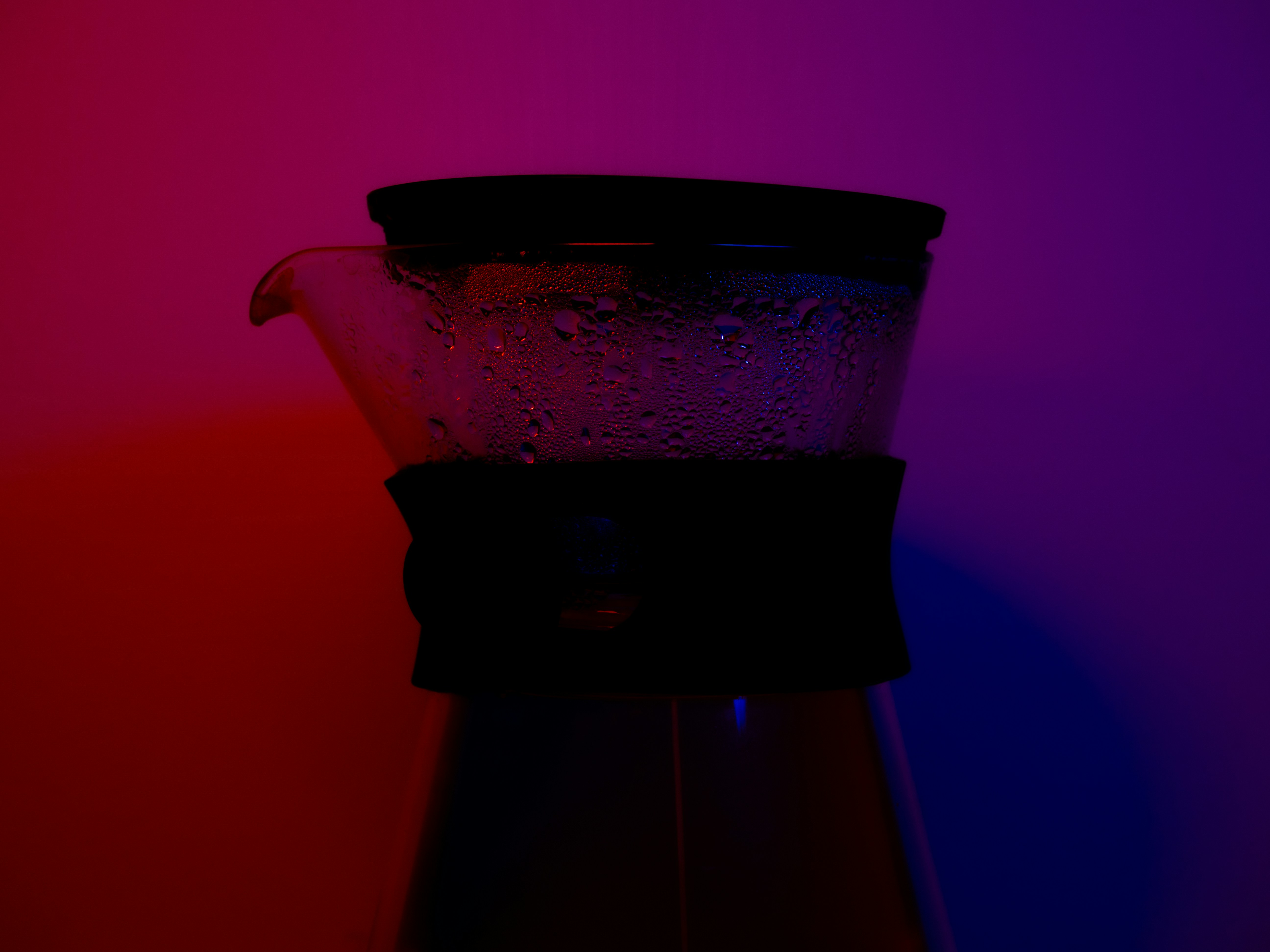 Dark glass carafe against vibrant red and blue light