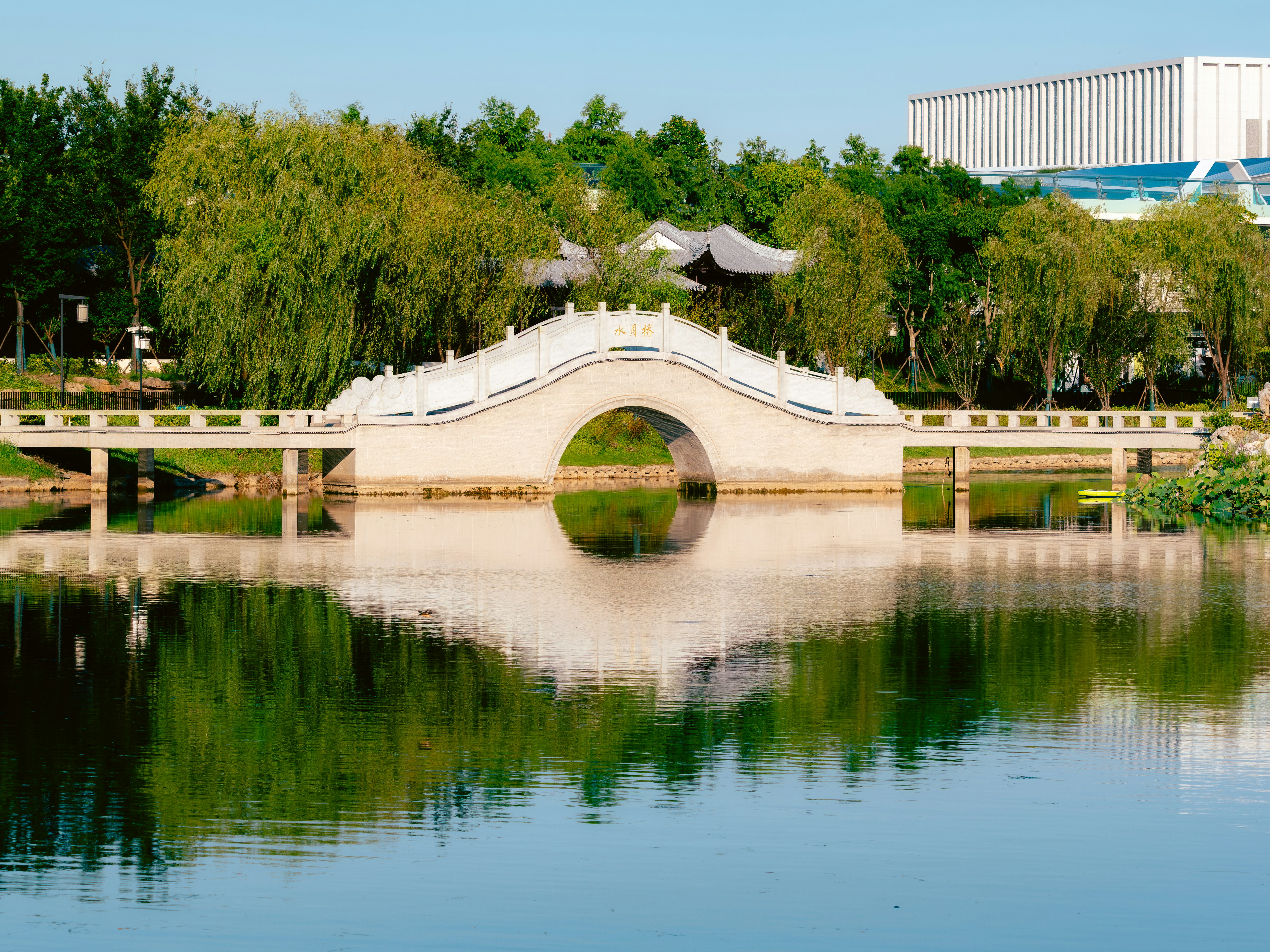 White arched bridge reflecting in calm water