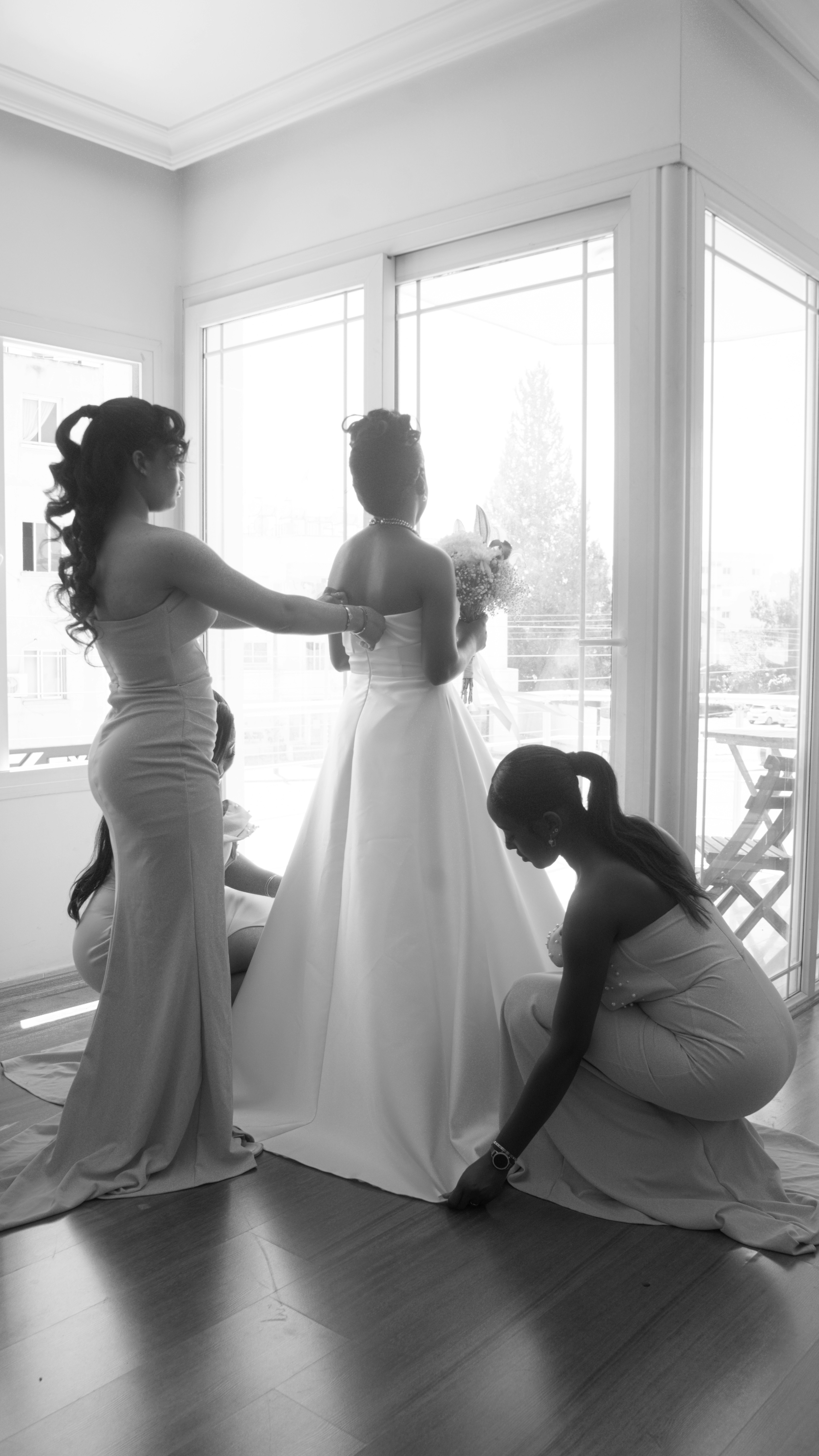 Bridesmaids helping the bride with her wedding dress.