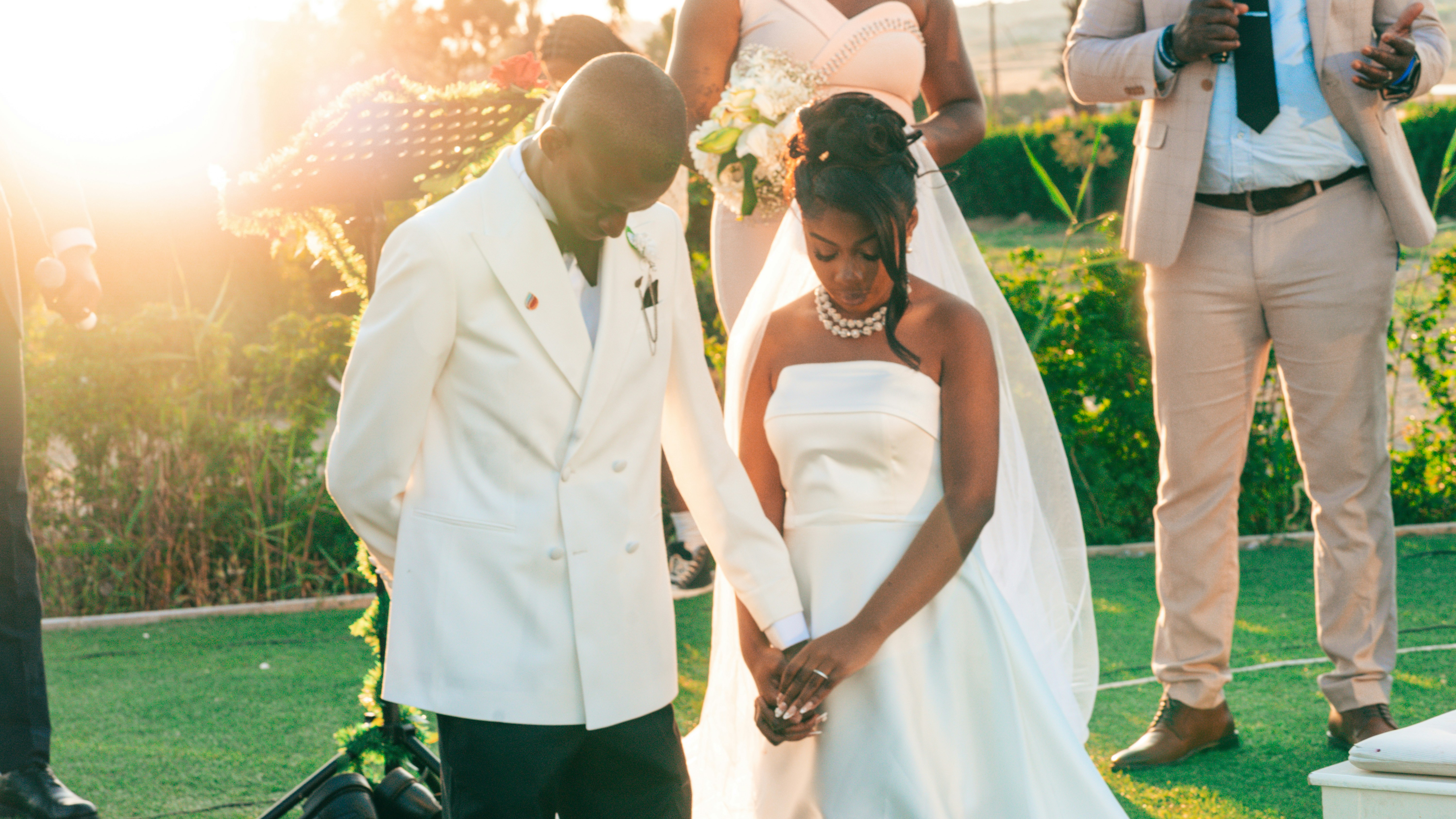 Wedding couple bowing their heads during an outdoor ceremony.
