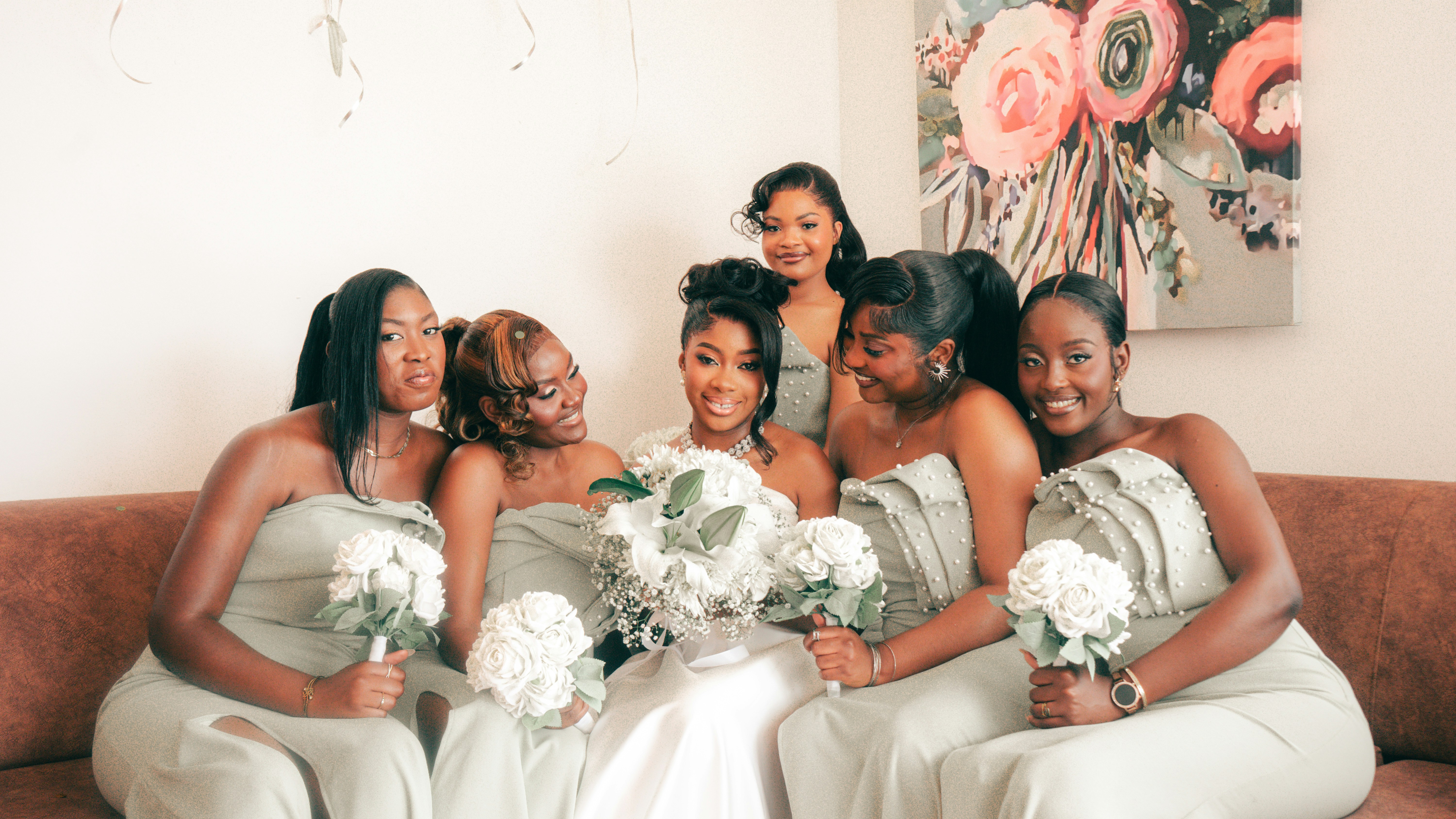 A bride and her bridesmaids smiling with bouquets.