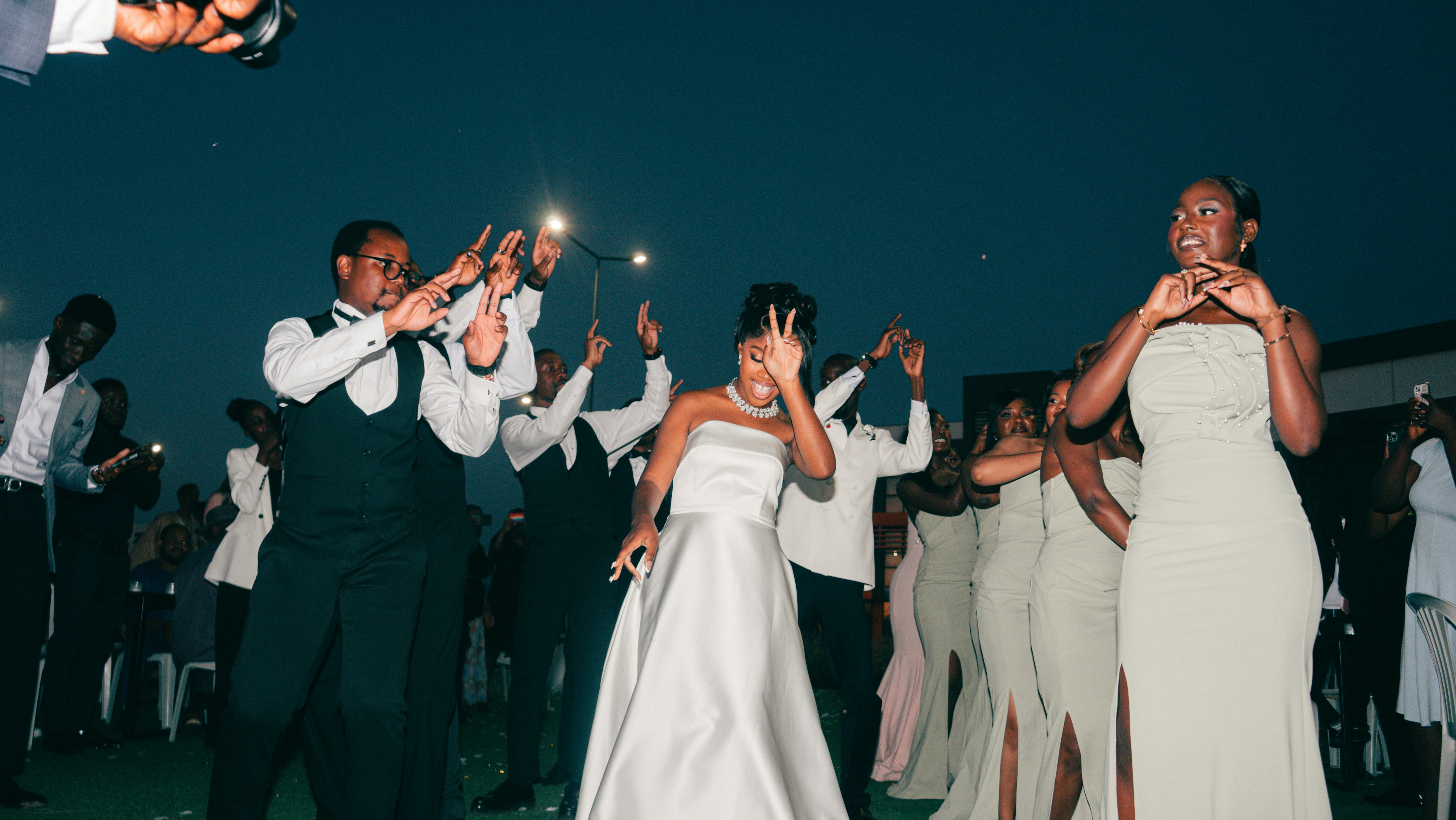 People in formal attire dancing outdoors at night.