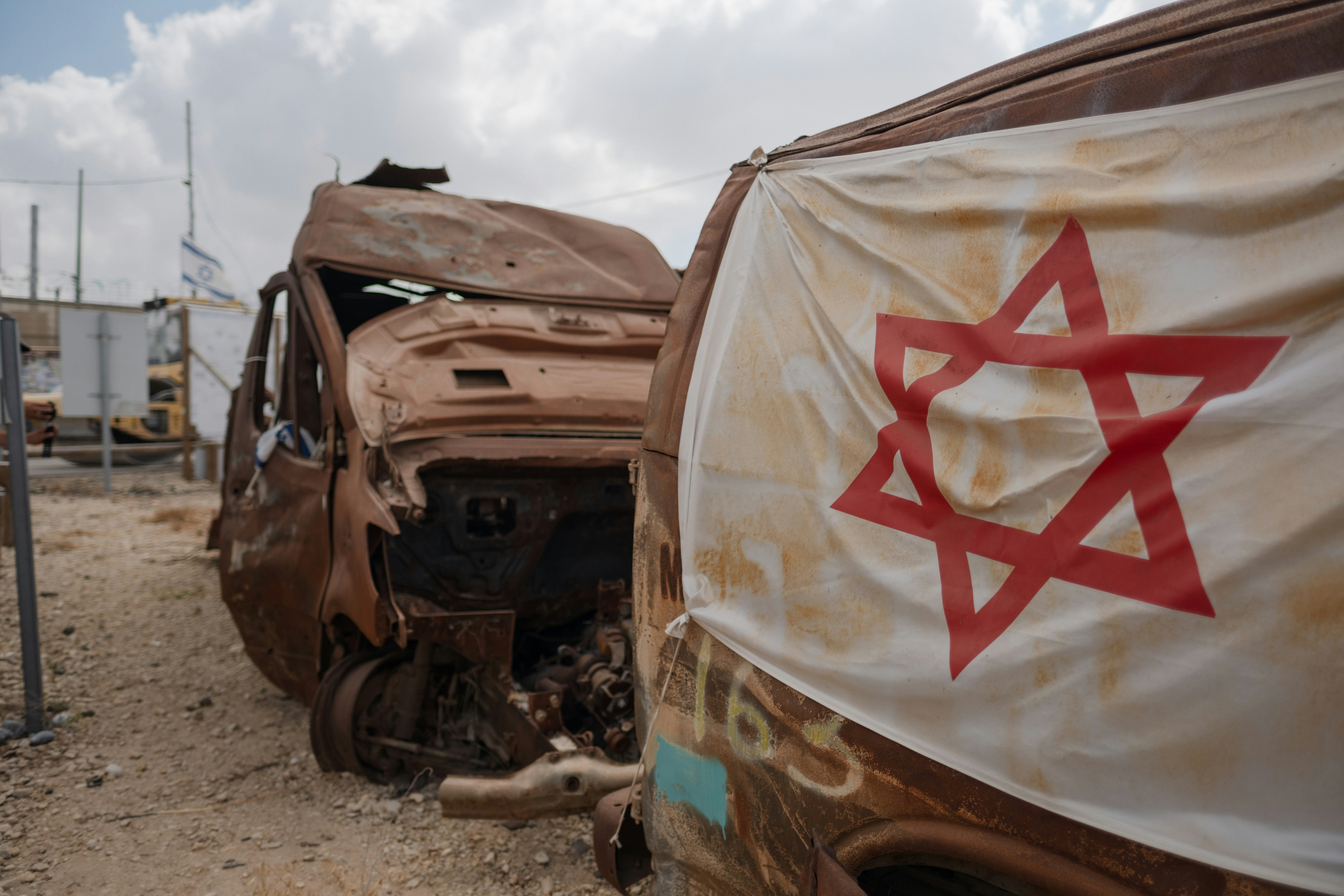 Israeli flag draped over burnt-out vehicles
