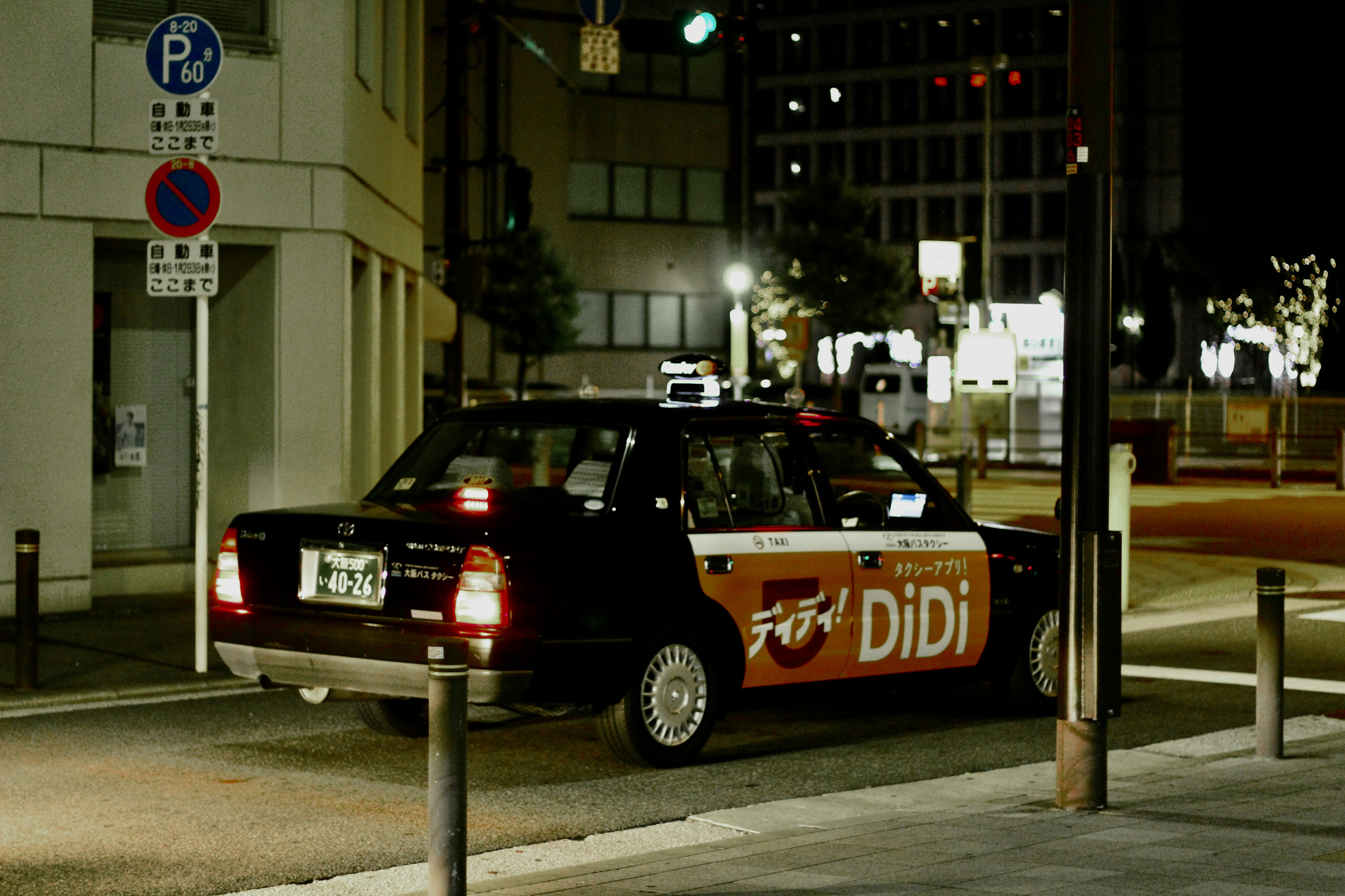A black didi taxi on a city street at night.