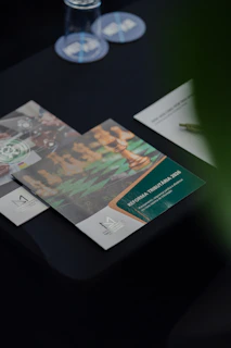 Folletos corporativos impresos con fotografías y bloques de información sobre una mesa oscura