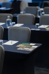 Empty conference room with tables, chairs, water, and brochures