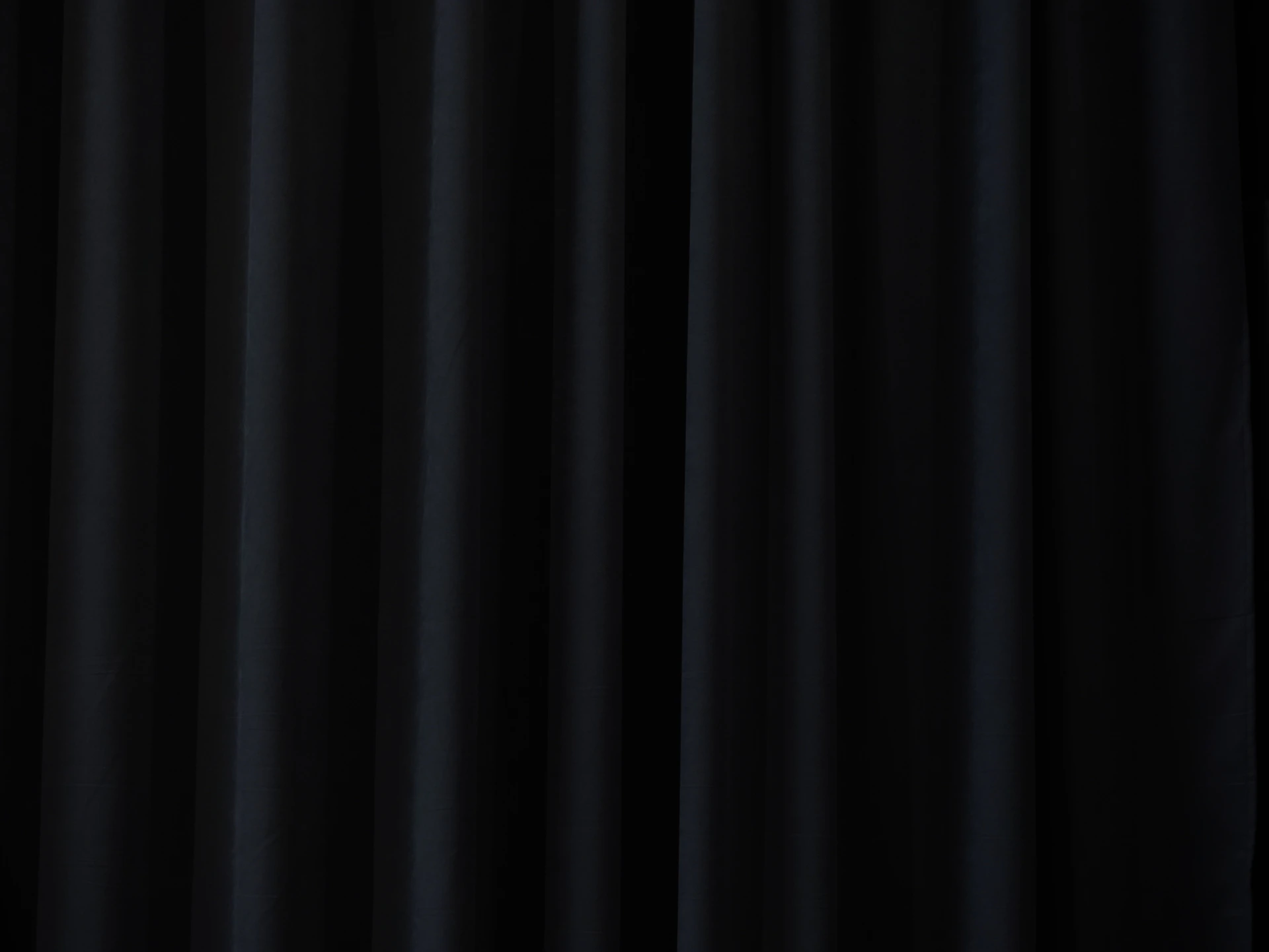 Dark blue draped fabric with vertical folds