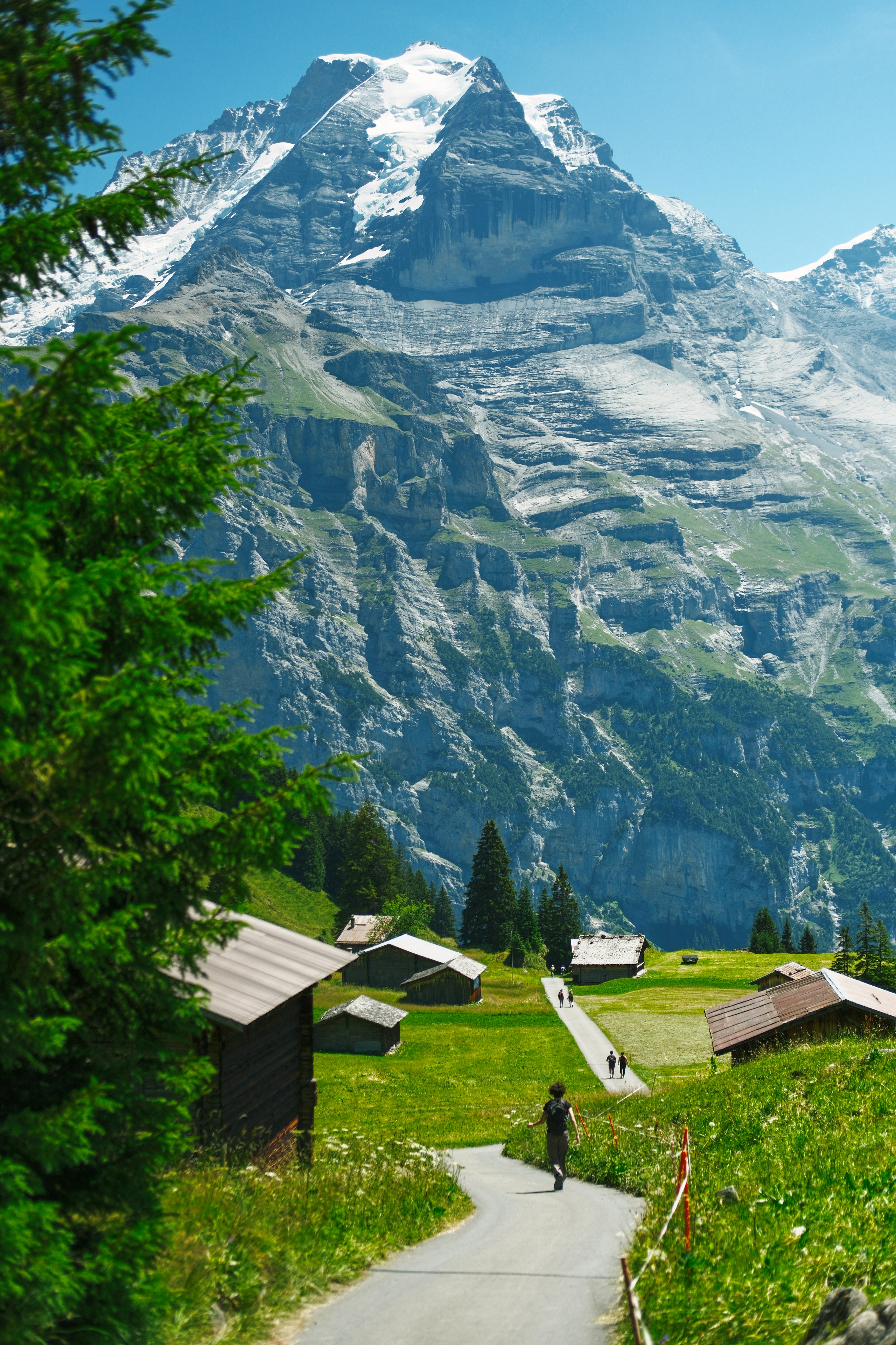 Snow-capped mountain overlooks a village and winding walking path
