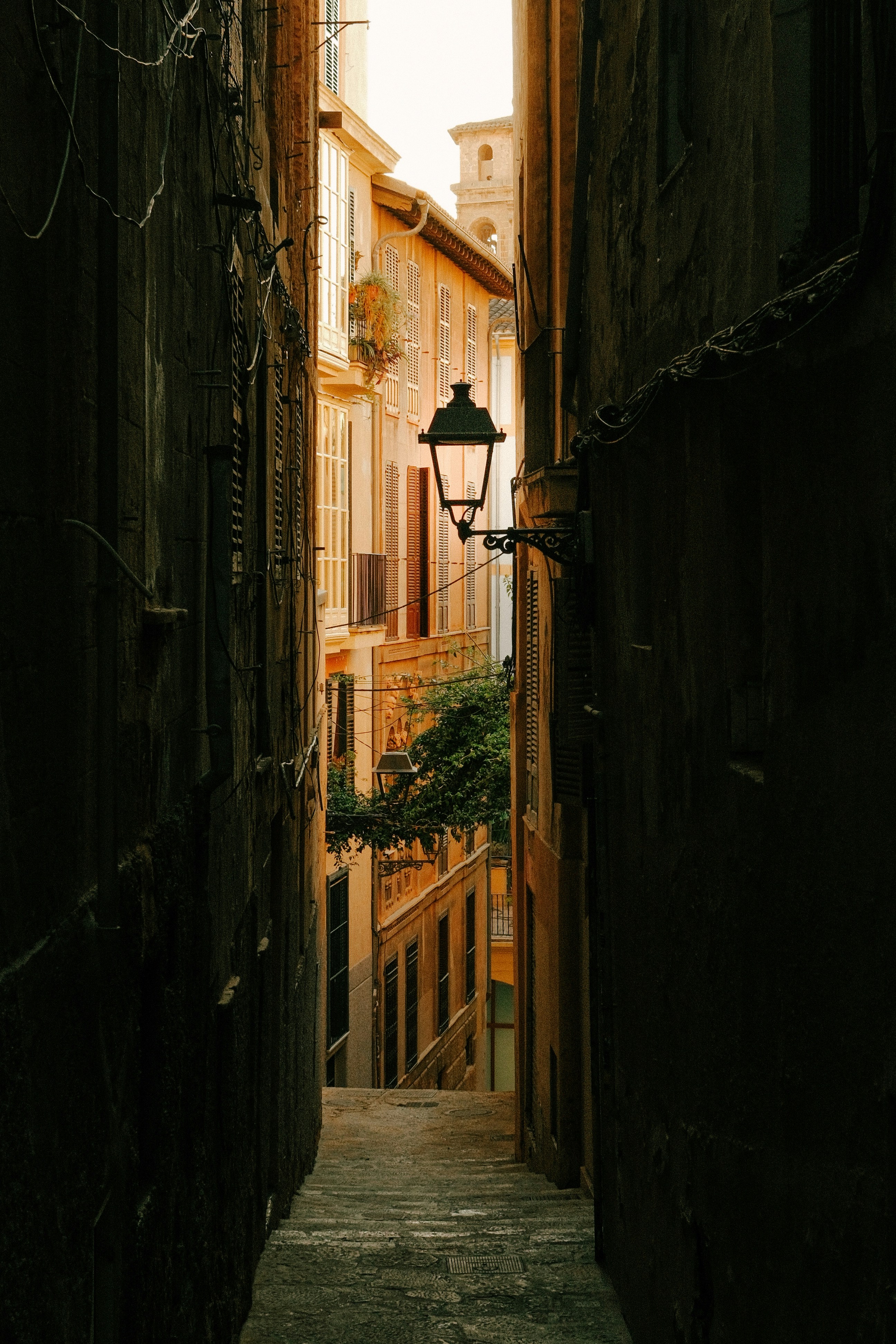 Dark, narrow alleyway with an antique street lamp.