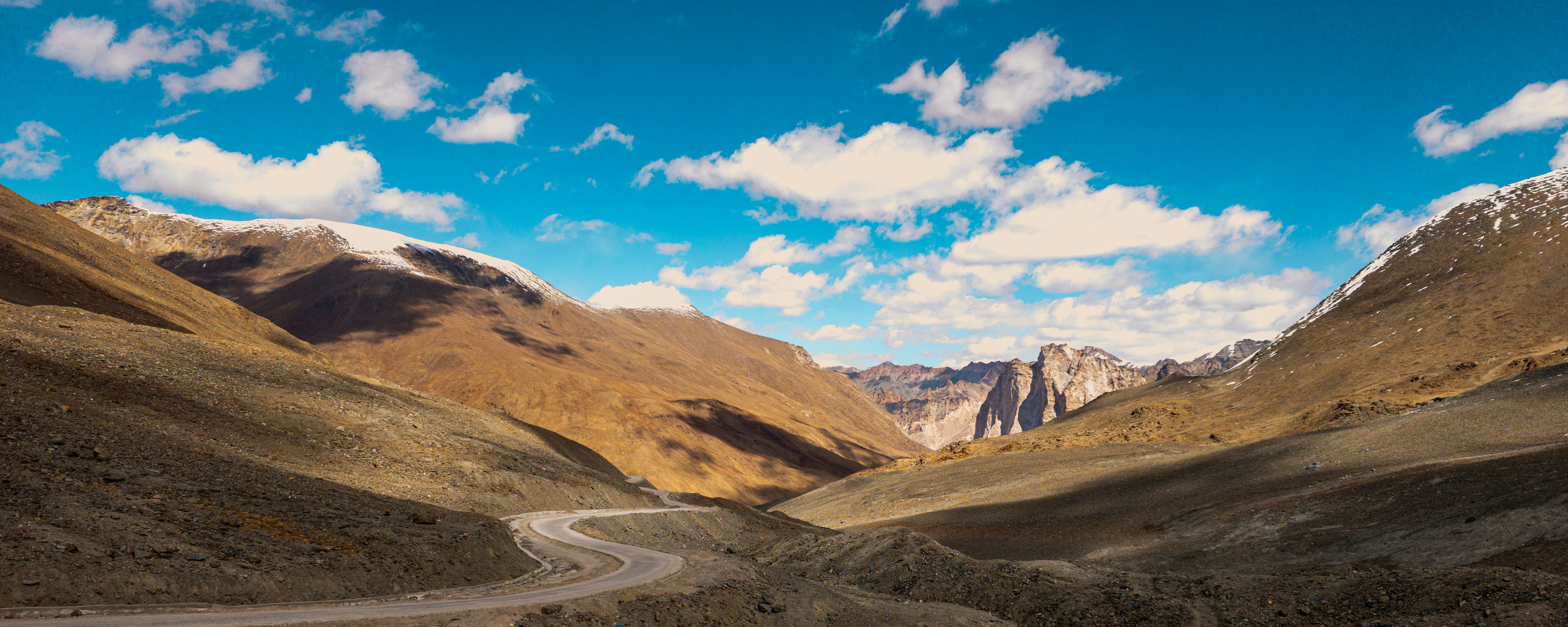 Scenic dirt road winding through a vast mountain valley.
