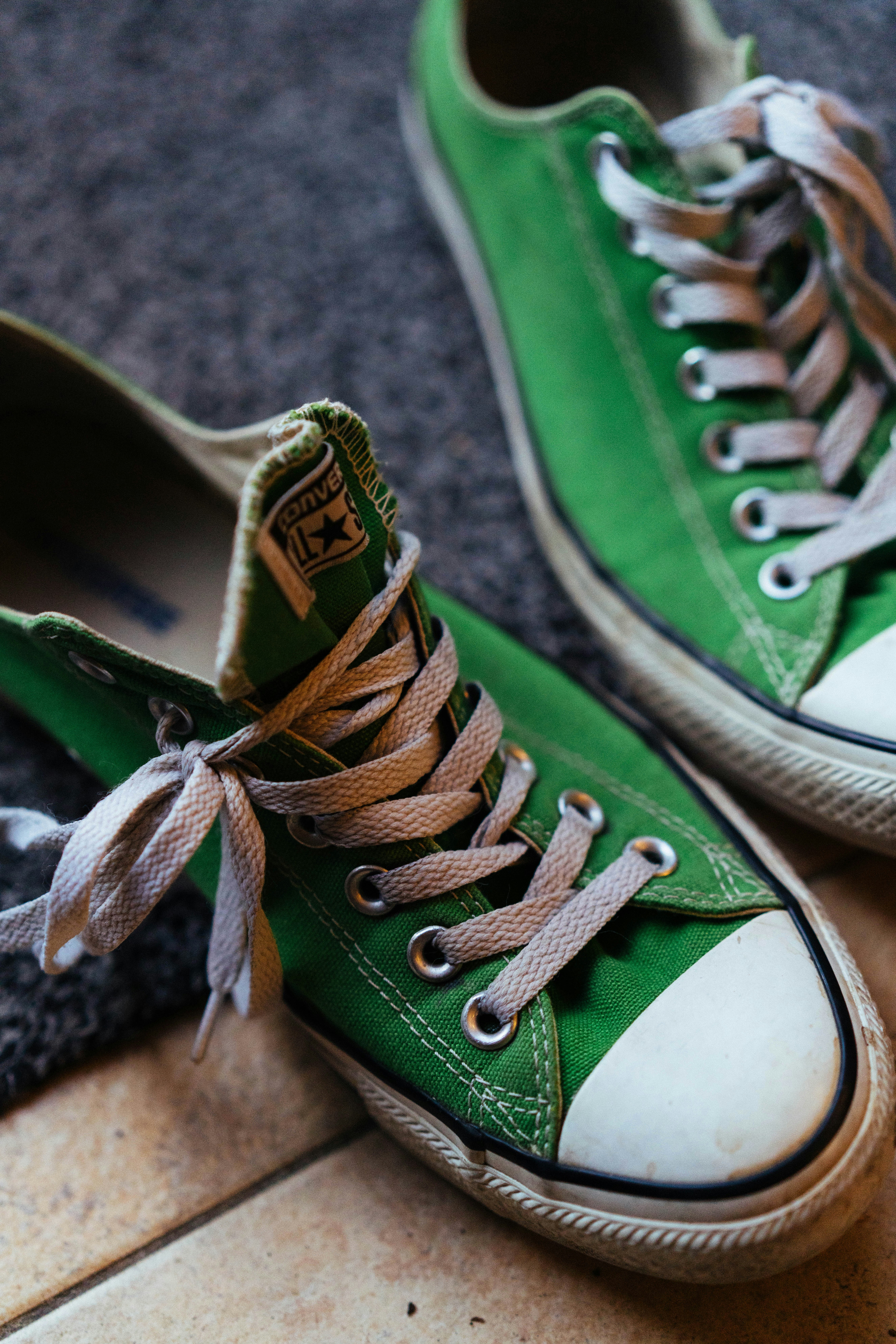 A pair of green converse sneakers with white laces.